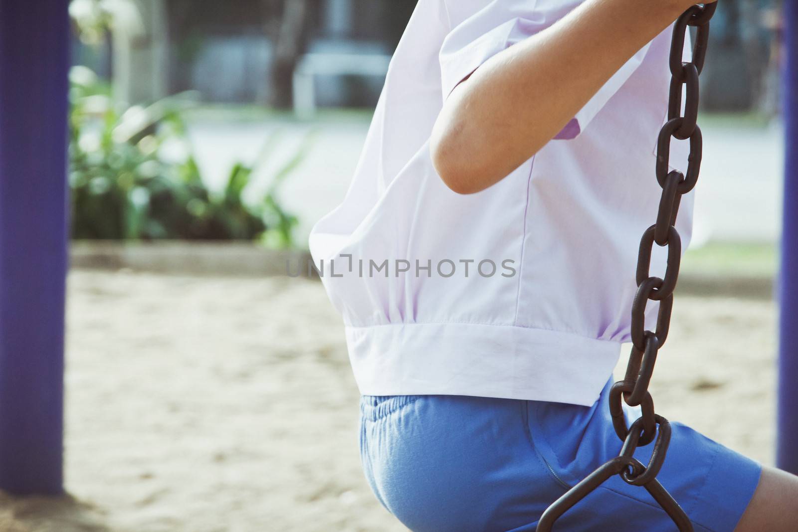 Little child on a swing in the park.