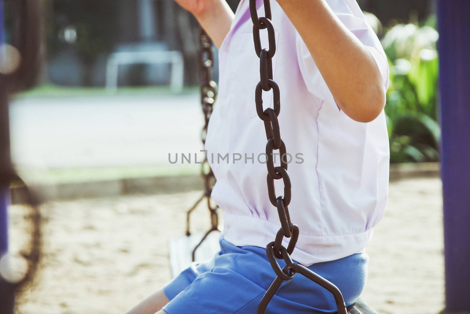 Little child on a swing in the park.