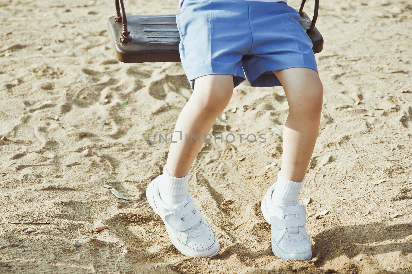 Little child on a swing in the park.