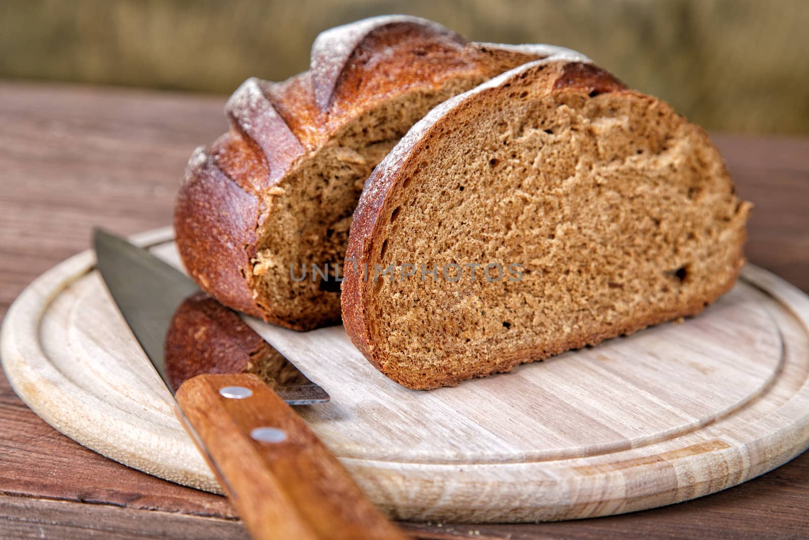 The cut black bread on a wooden table