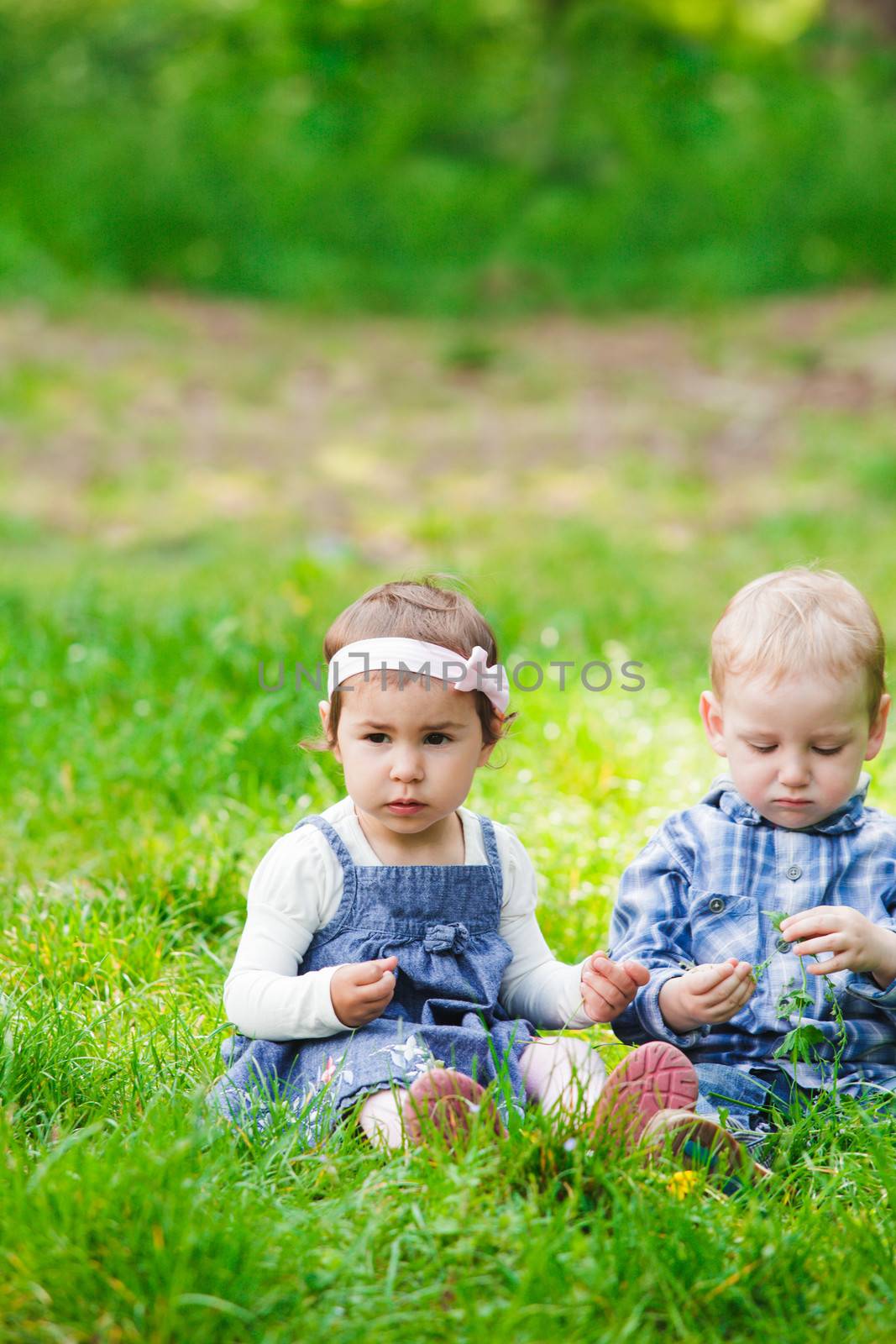 Little kids play outdoors on the grass