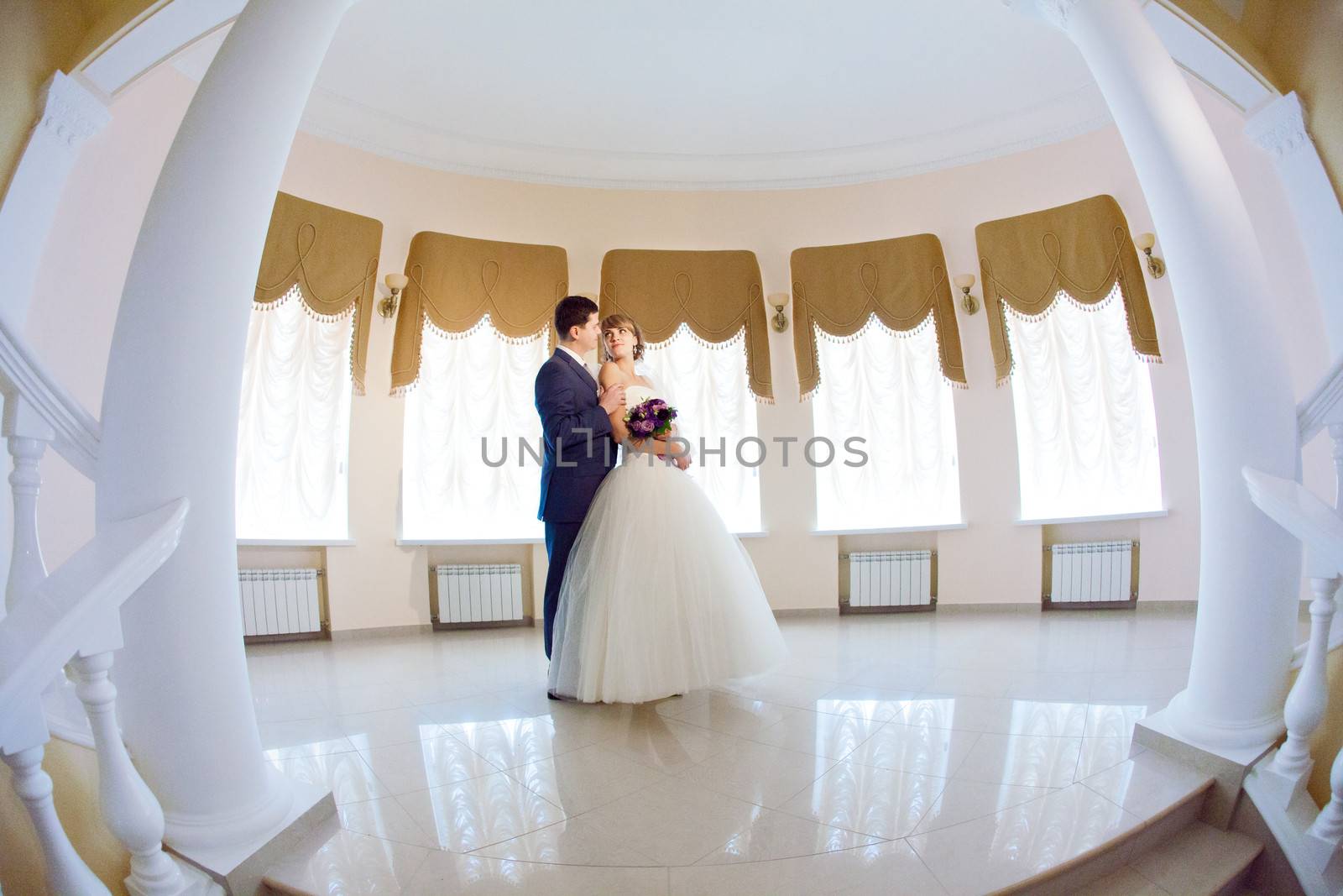 groom and bride in hall with staircase by vsurkov
