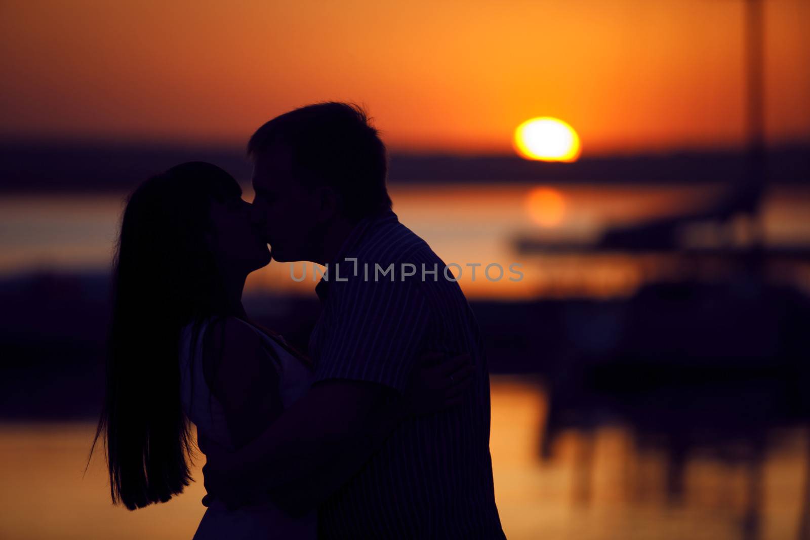 kissing couple in sunset by vsurkov