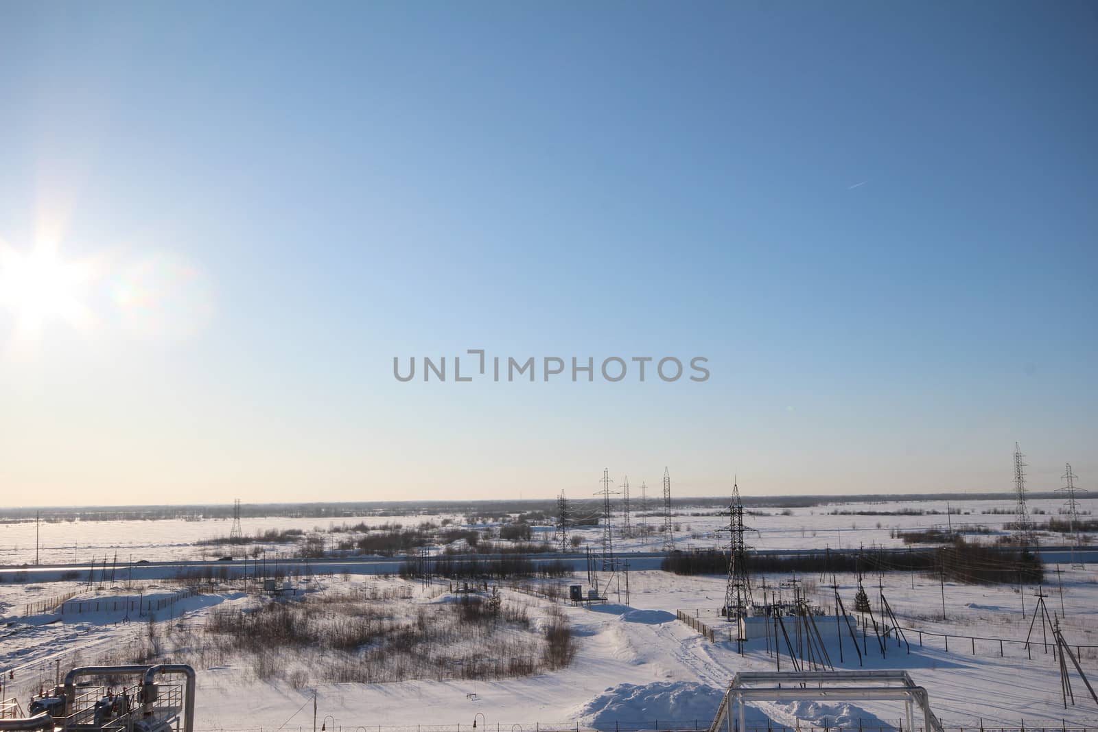 Industrial zone. High voltage power lines and metal pipes. winter Landscape