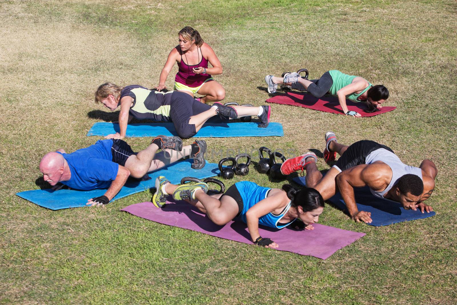 Young fitness instructor working with mixed group of adults