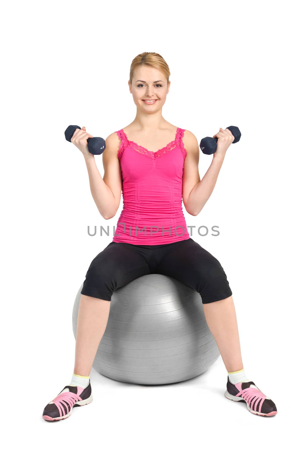 young woman posing with dumbbells sitting on fitness ball, on white background
