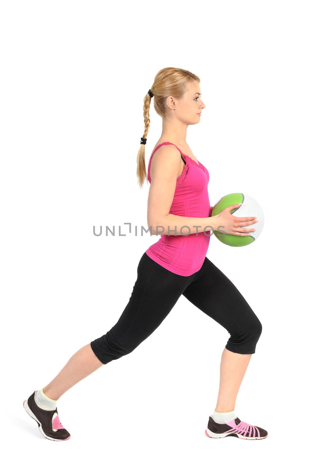 Young girl doing lunges exercise with medicine ball