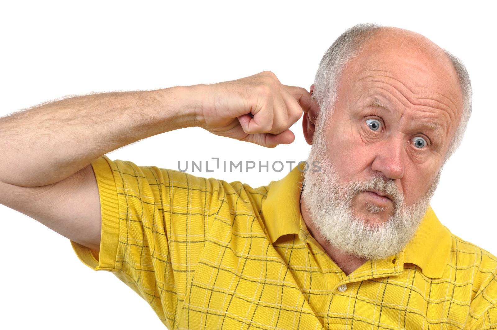 goofy bald senior man picking his ear with index finger
