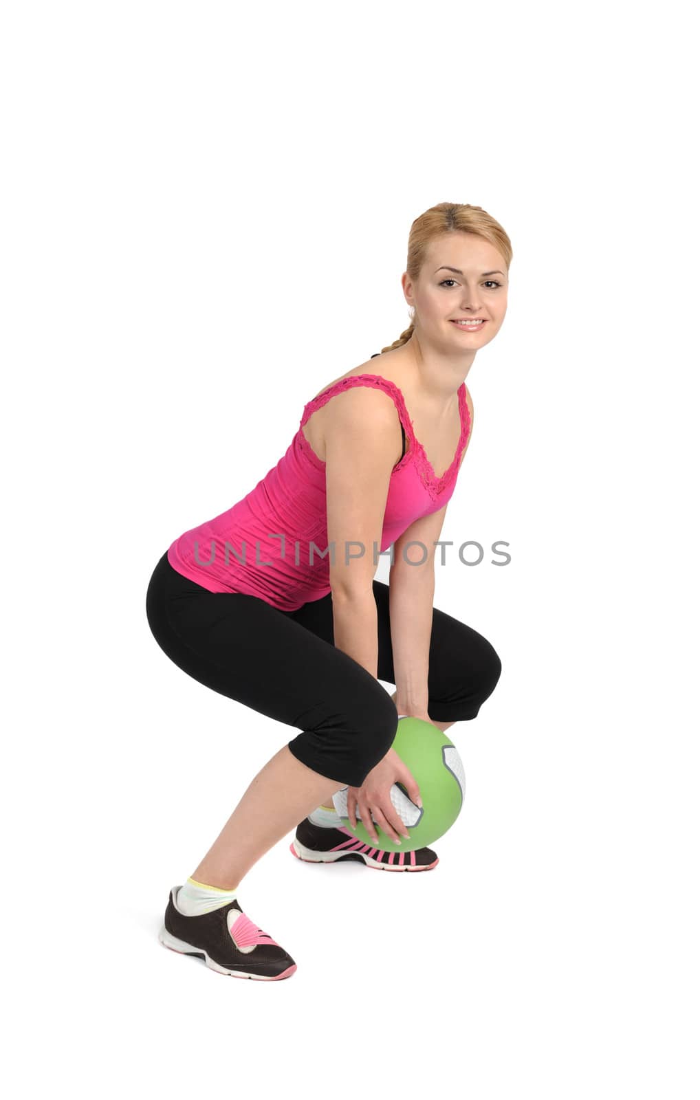 Female exercise with medicine ball. Phase 1 of 2, squatting before throw.