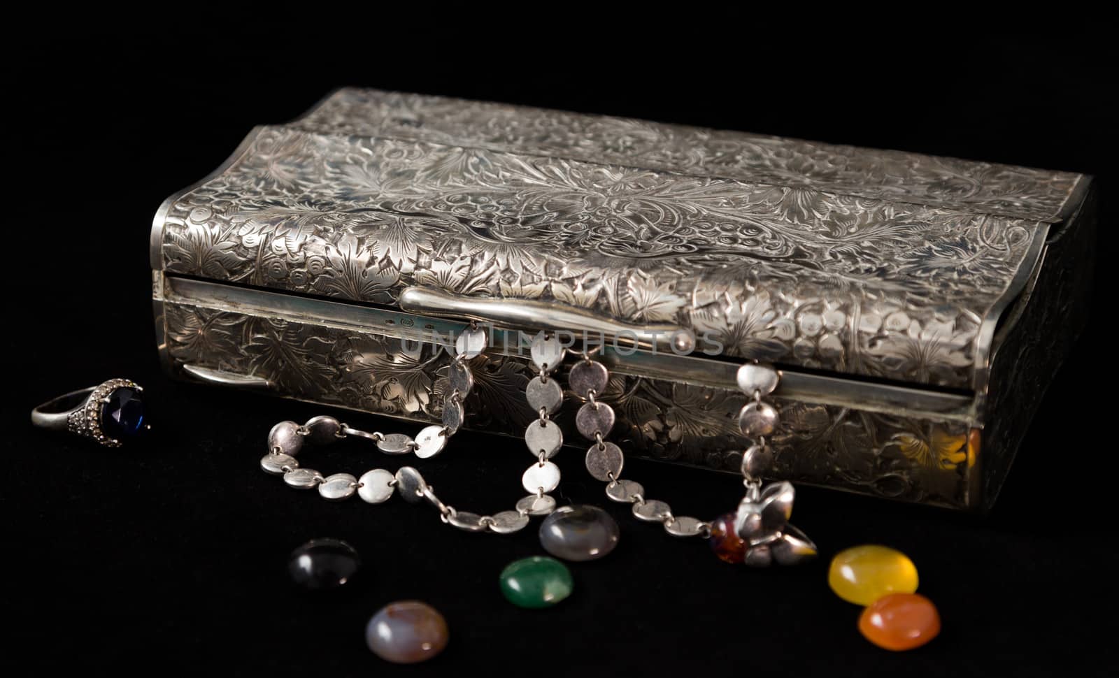 jewelery box with silver necklaces, rings and precious stones