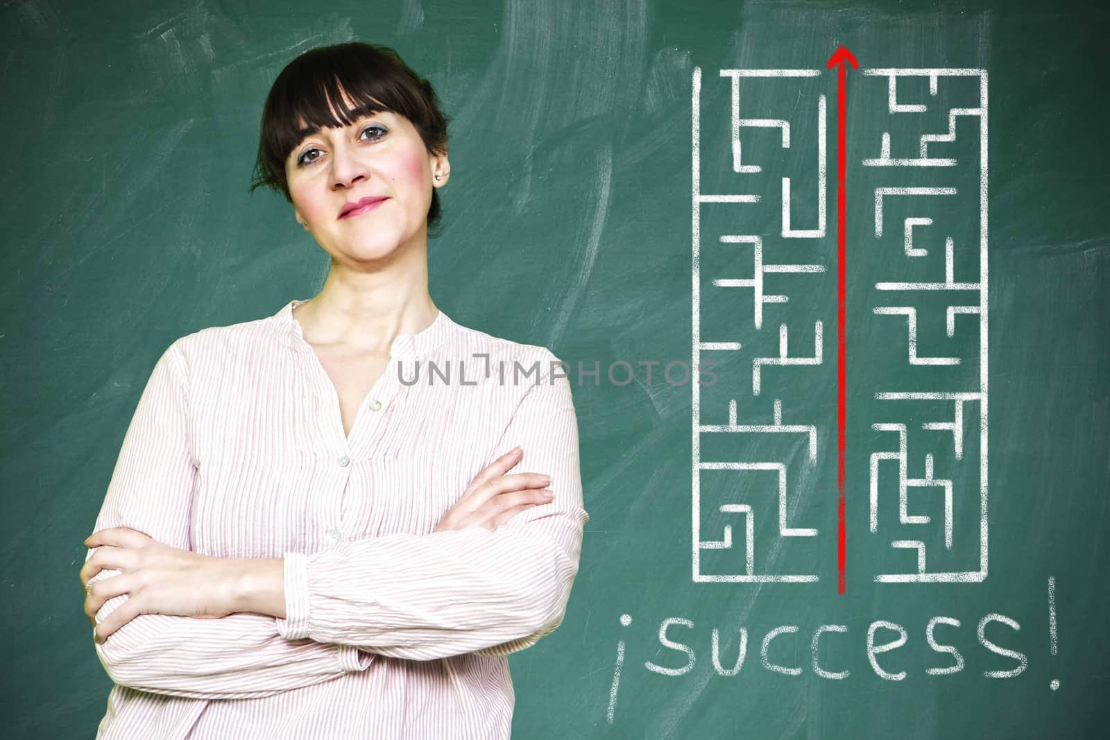 Woman smiles writes on a blackboard to learn concept