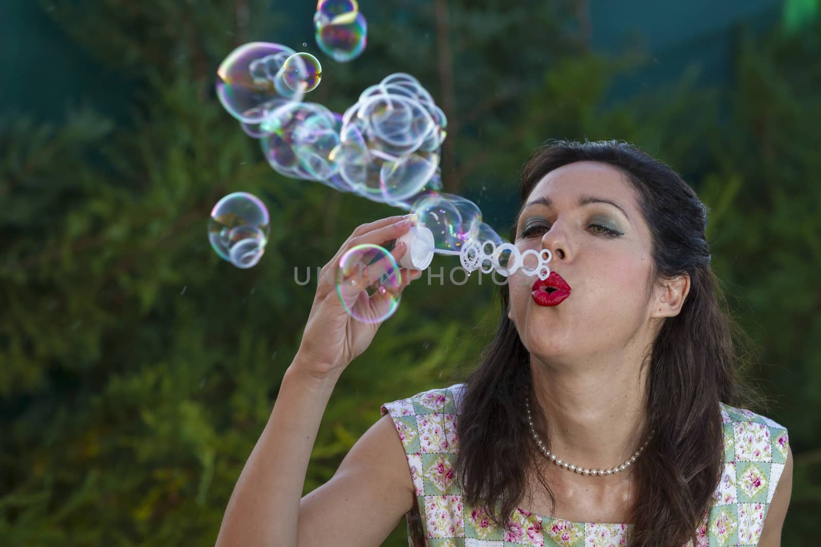 a beautiful woman blowing bubbles. spring season, rural scene