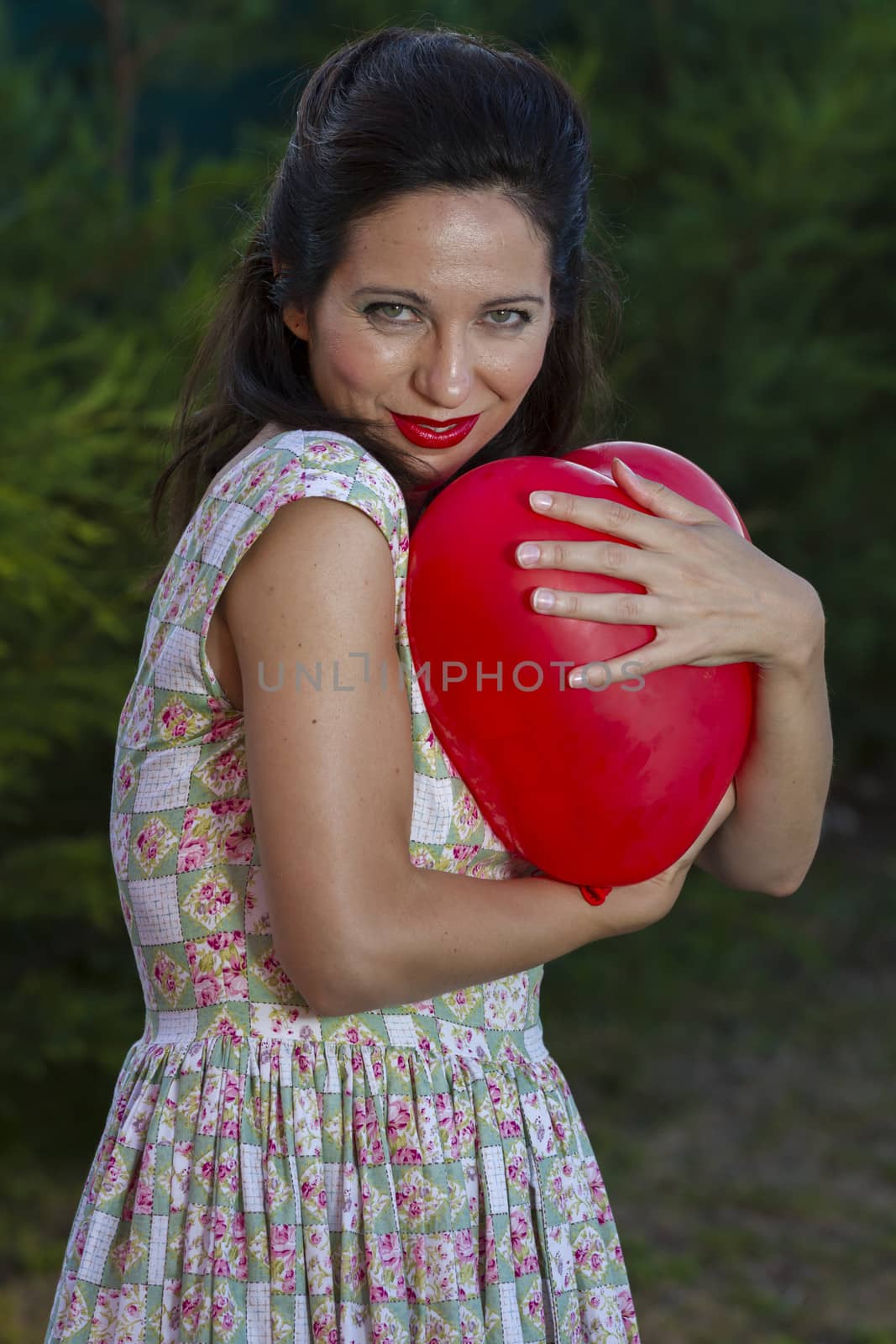 Valentine's Day. Beautiful smiling woman with a gift in the form of heart in his hands