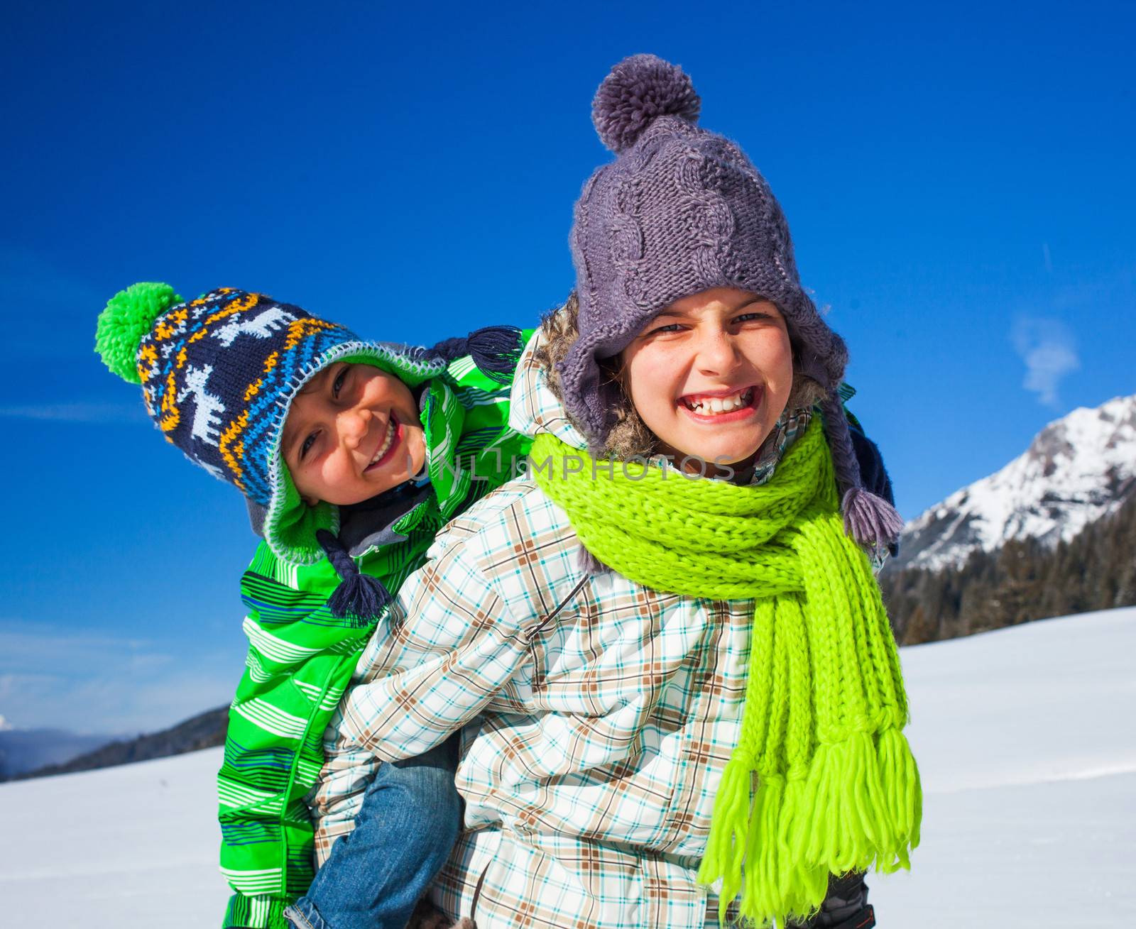 Two happy kids playing winter on the snow in Alps