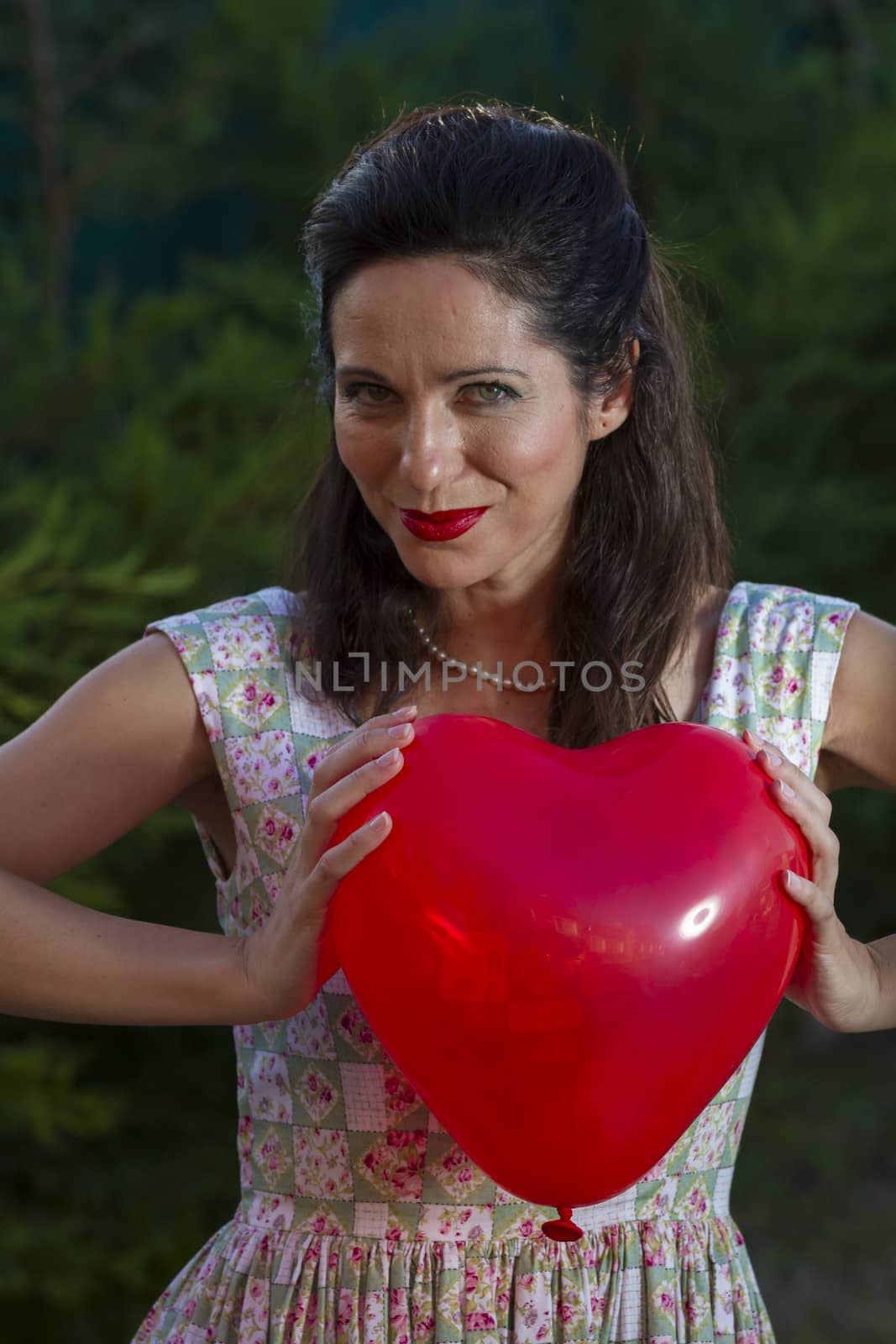 Valentine's Day. Beautiful smiling woman with a gift in the form of heart in his hands