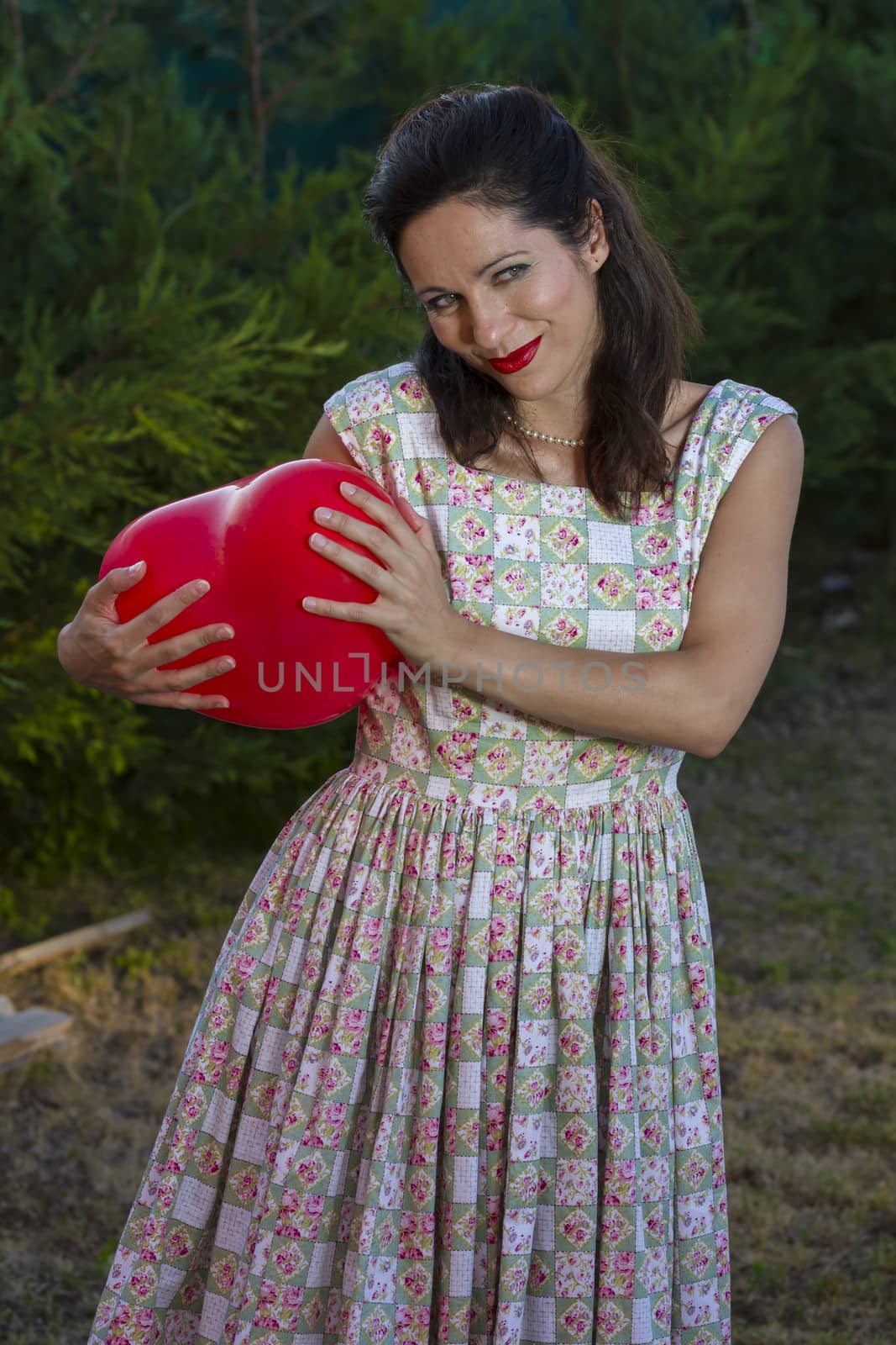 Valentine's Day. Beautiful smiling woman with a gift in the form of heart in his hands