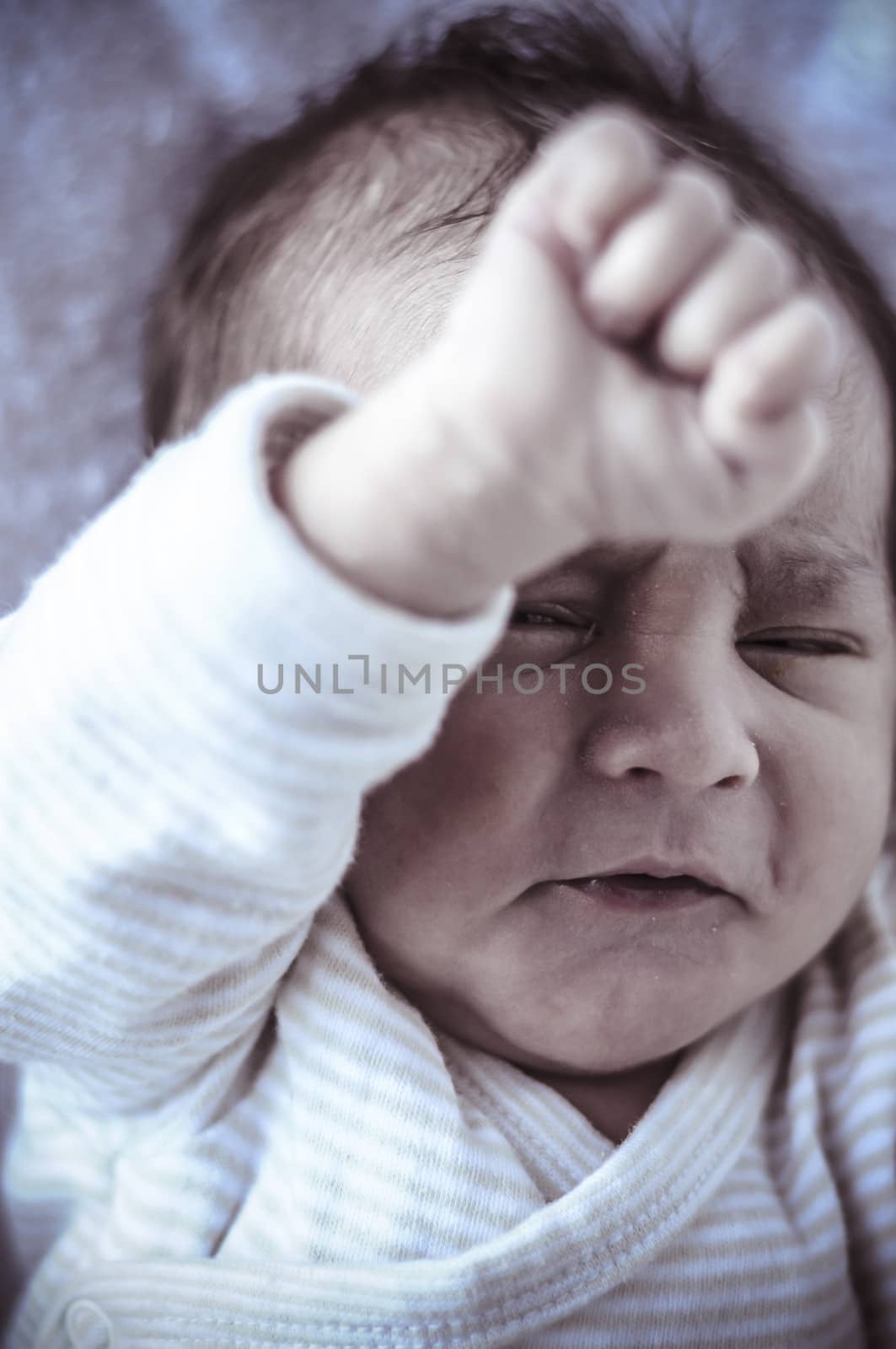 new born baby curled up sleeping on a blanket, multiple expressions