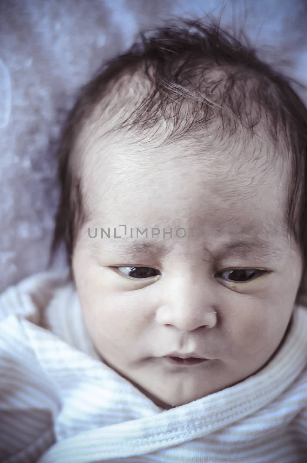 new born baby curled up sleeping on a blanket, multiple expressions