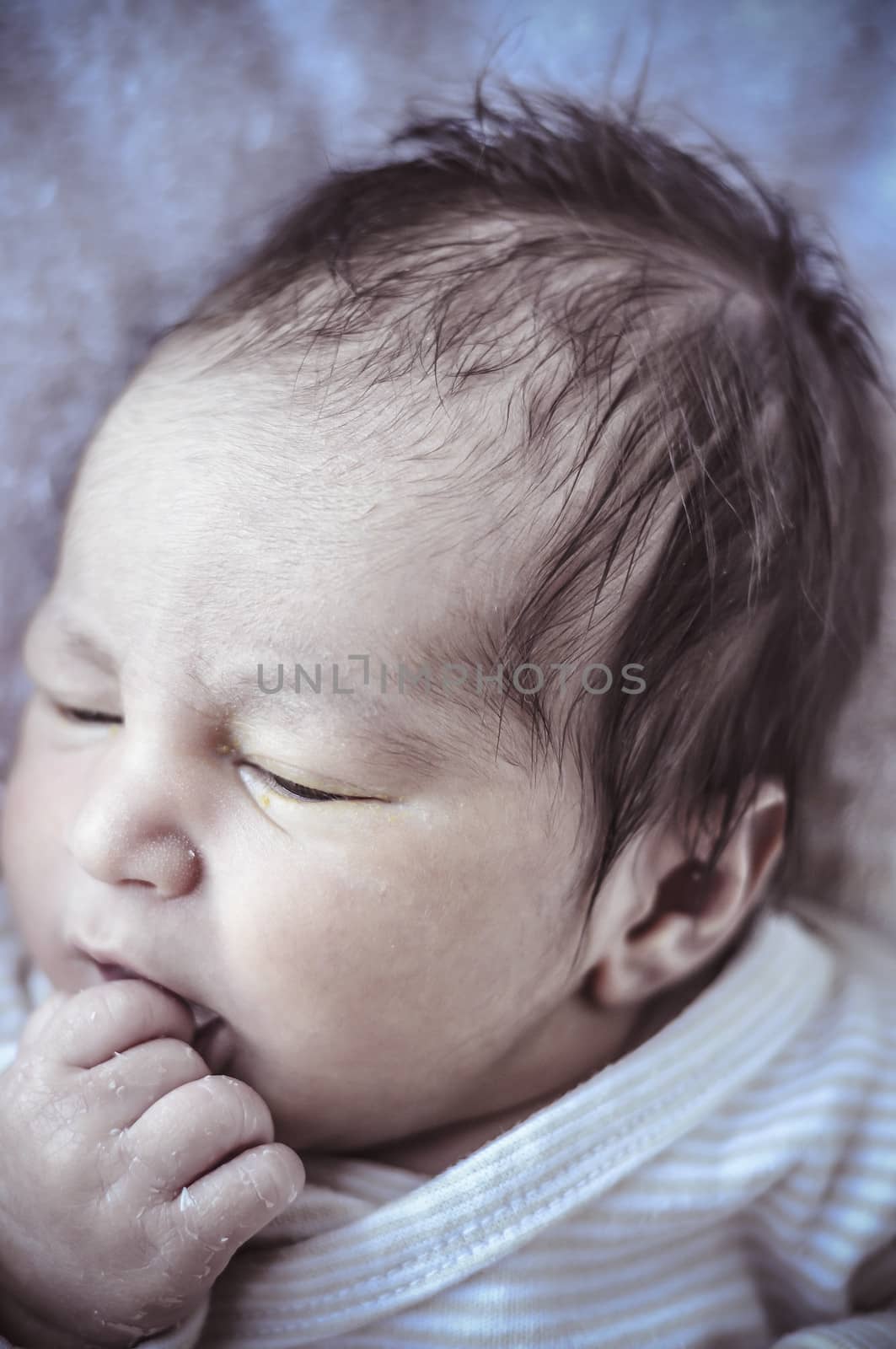 new born baby curled up sleeping on a blanket, multiple expressions