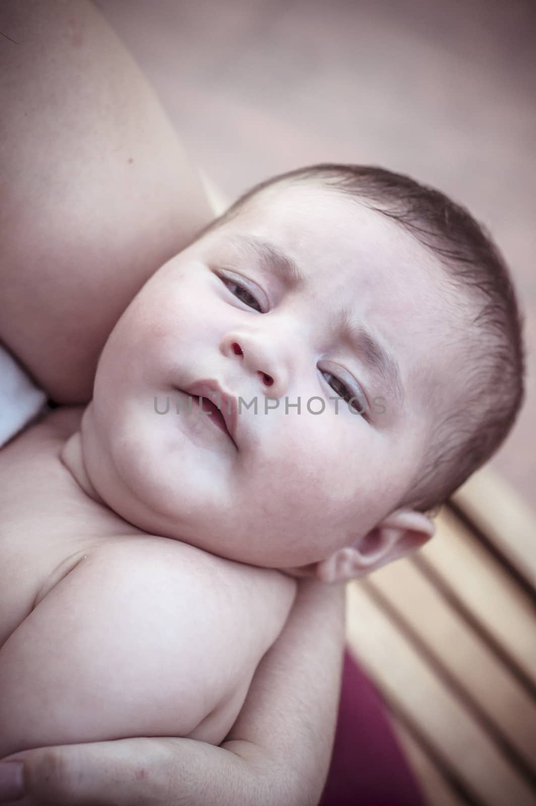 new born baby curled up sleeping on a blanket, multiple expressions