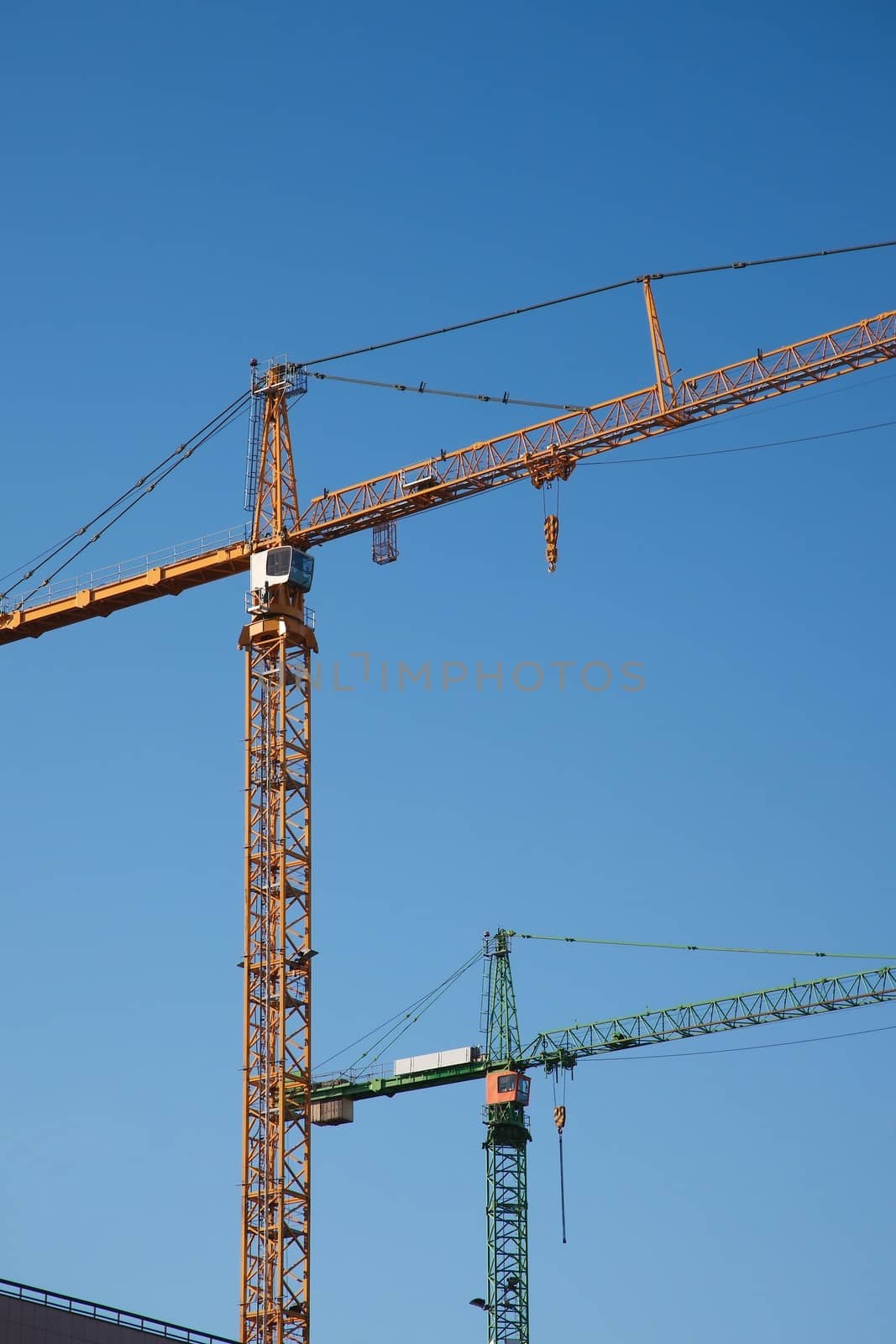 Tower cranes against clear blue sky