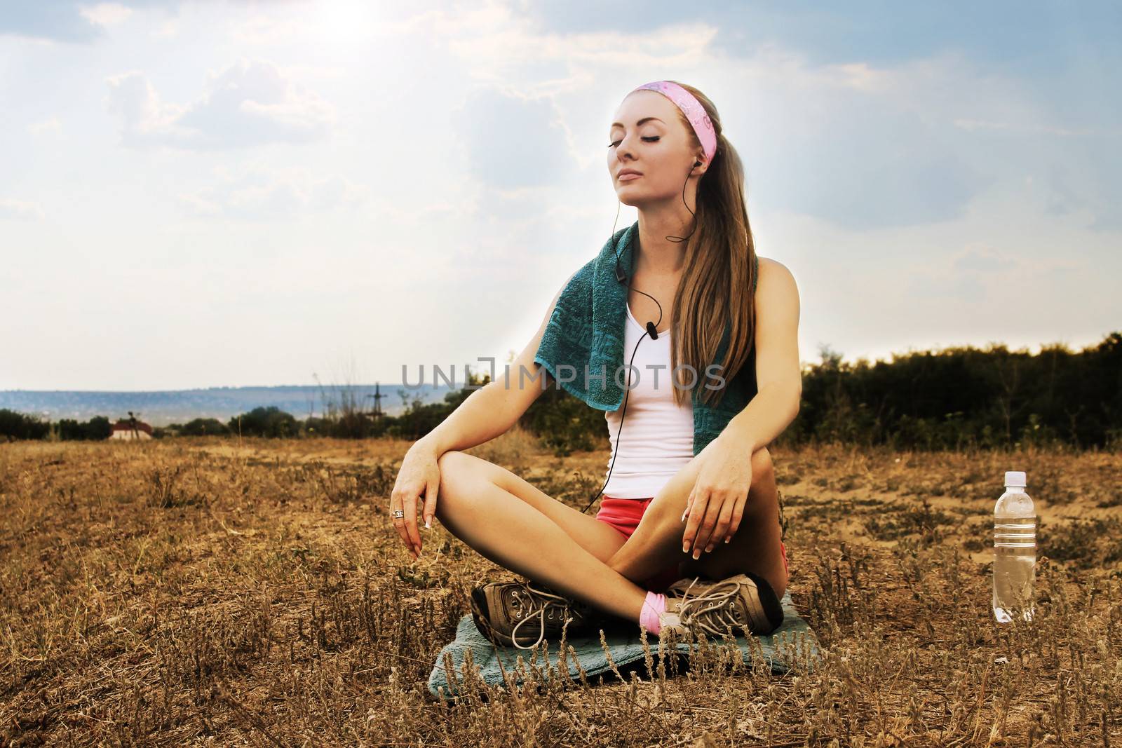 Sporty woman with headphones meditates by Angel_a