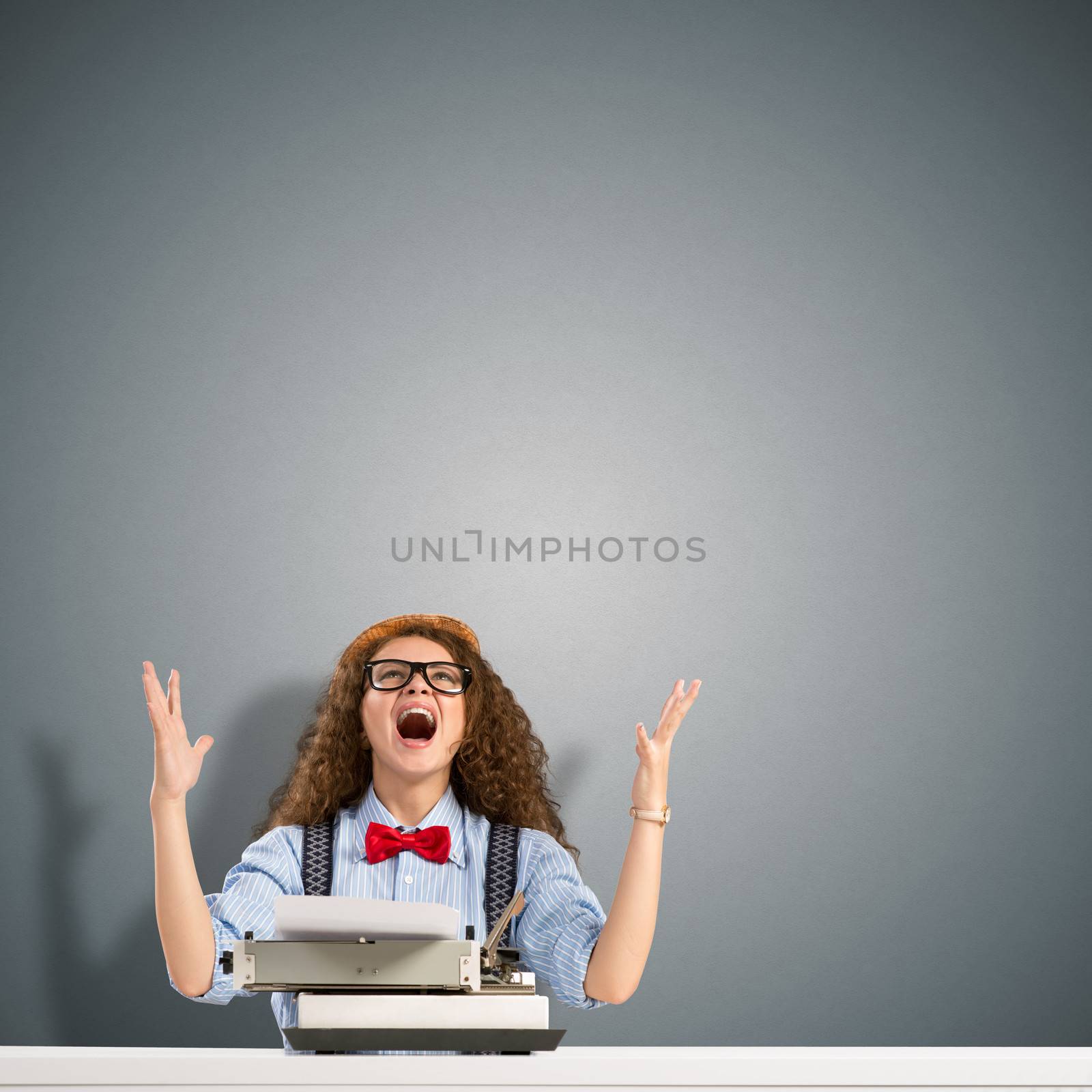 image of a young woman writer at the table with typewriter