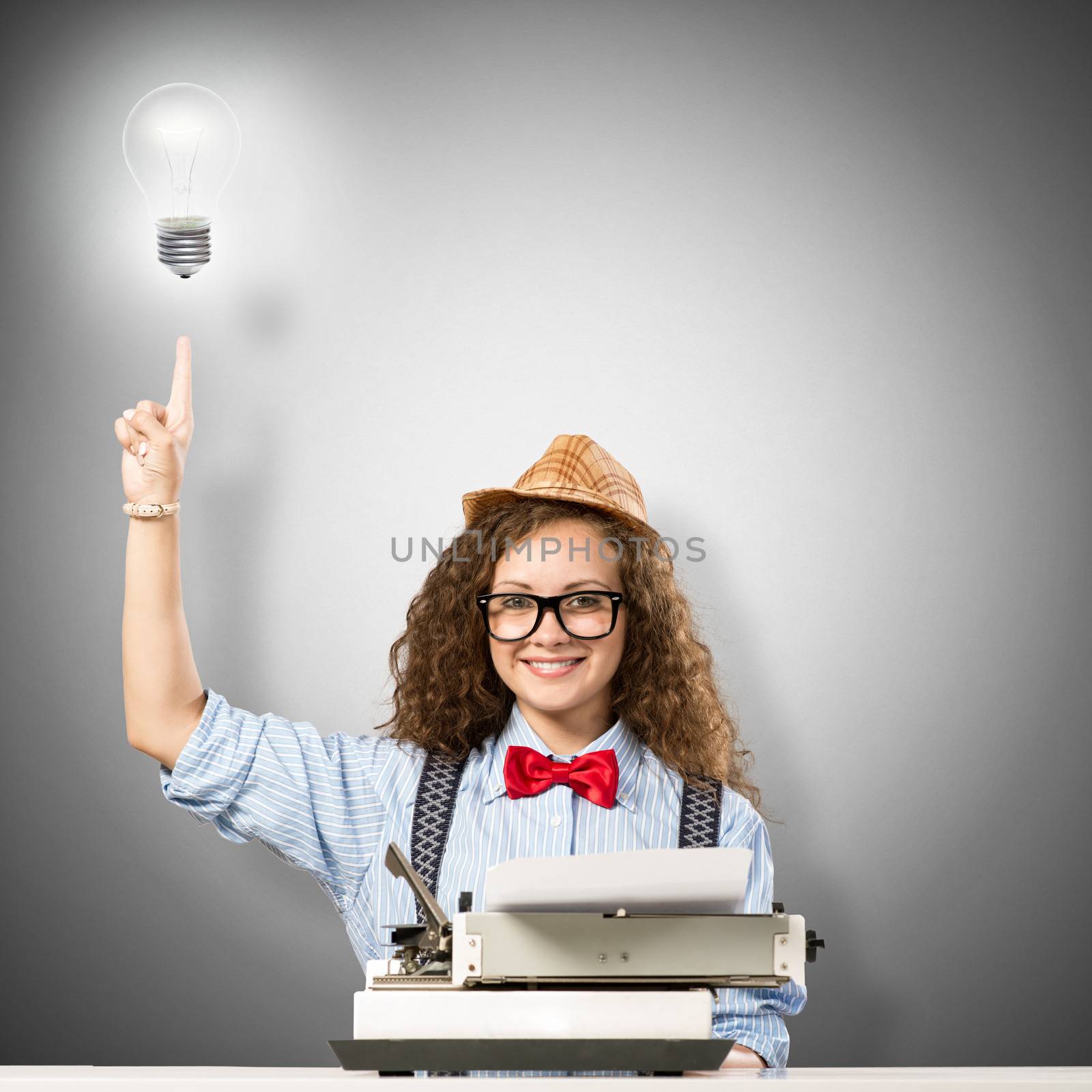 image of a young woman writer at the table with typewriter