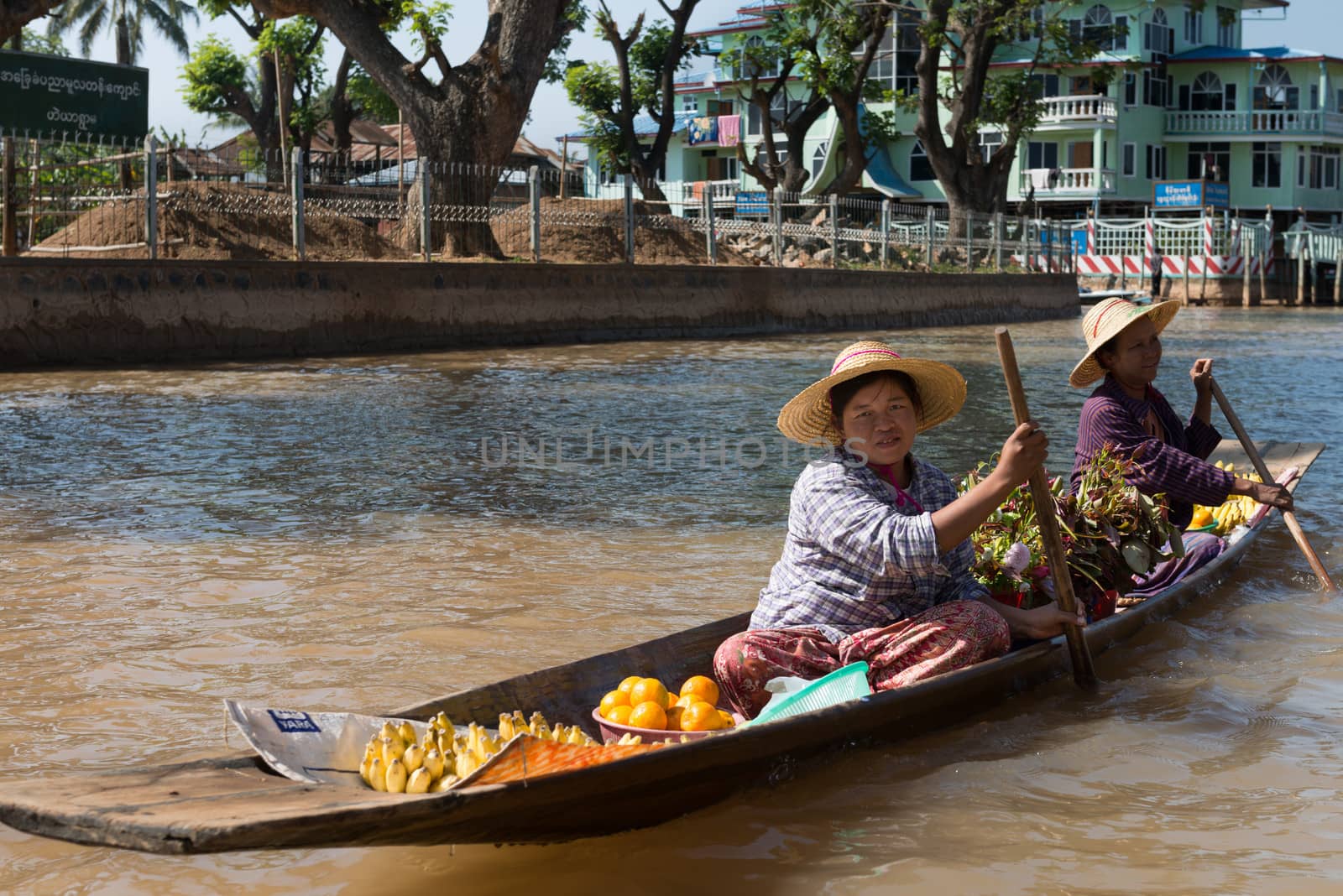 Floating asian vendors on long wooden boat by iryna_rasko
