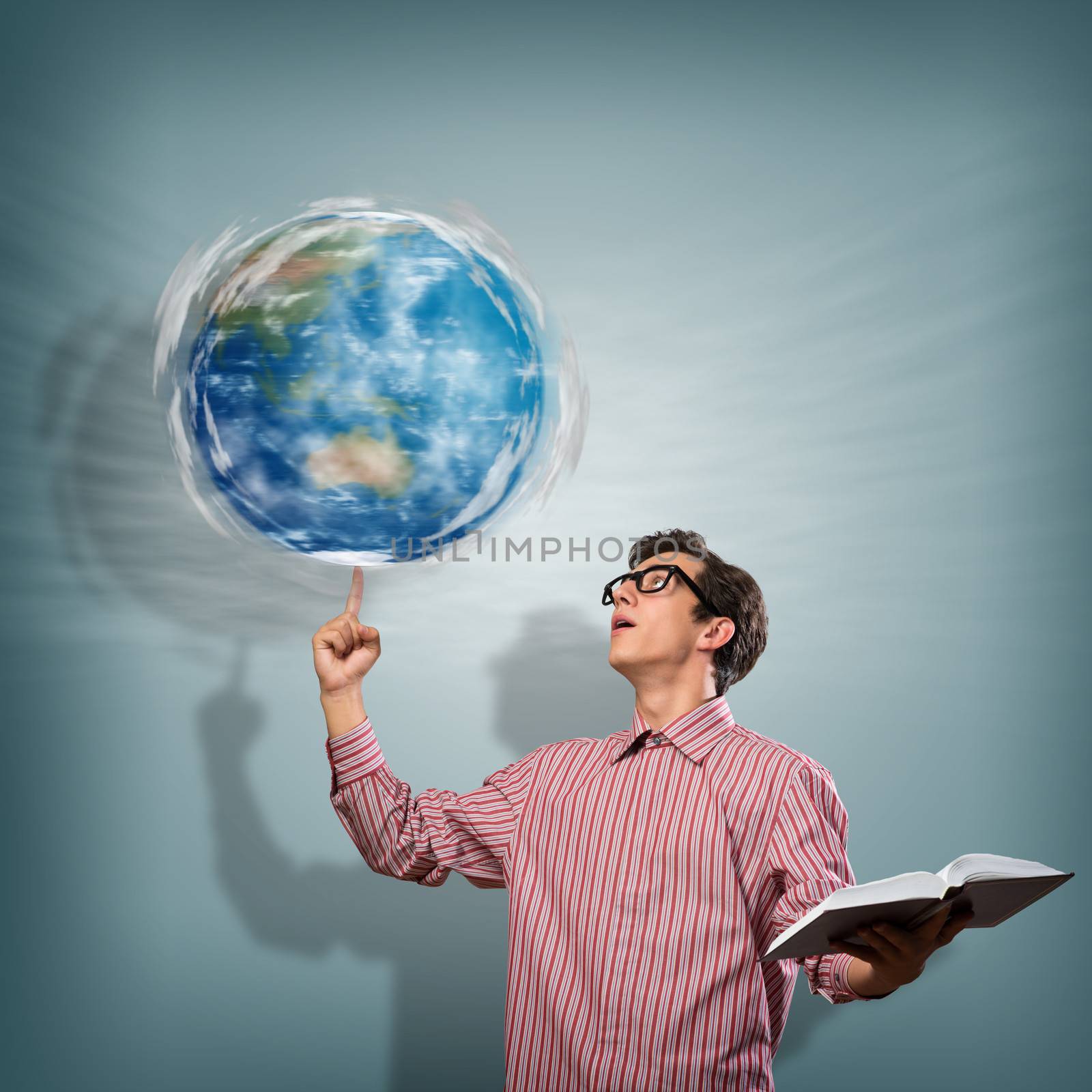 young man with a book thinks. keeps the finger symbol of the planet Earth. NASA images used