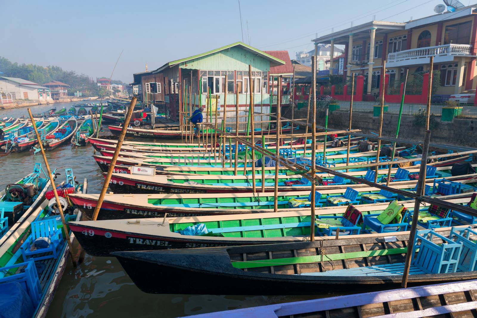 NYAUNG SHWE, INLE LAKE, MYANMAR (Burma) - 07 JAN 2014: Many long wooden tourist boats wait for customers at moorages. Most transportation on the lake is traditionally by boats.