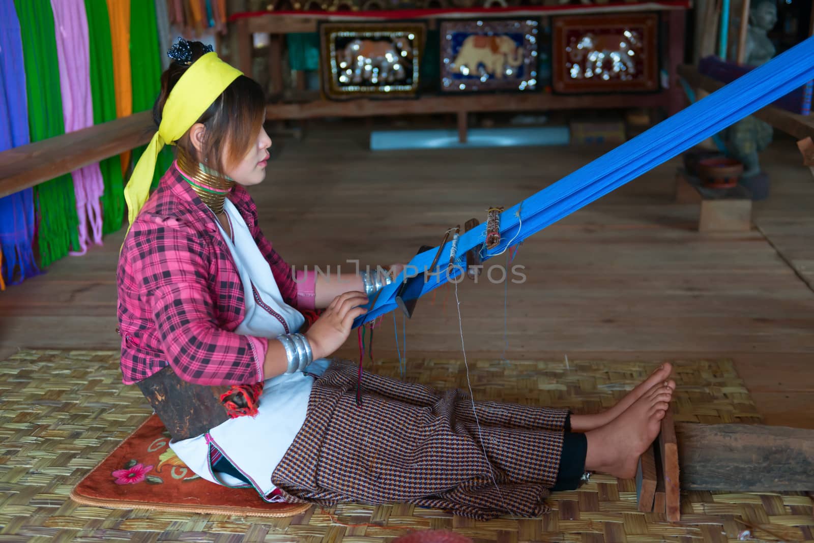 INLE LAKE, MYANMAR (BURMA) - 07 JAN 2014: Unidentified Padaung (Kayan Lahwi) tribe woman weave on traditional device. This tribe is called "long neck" because of metal rings around their necks.