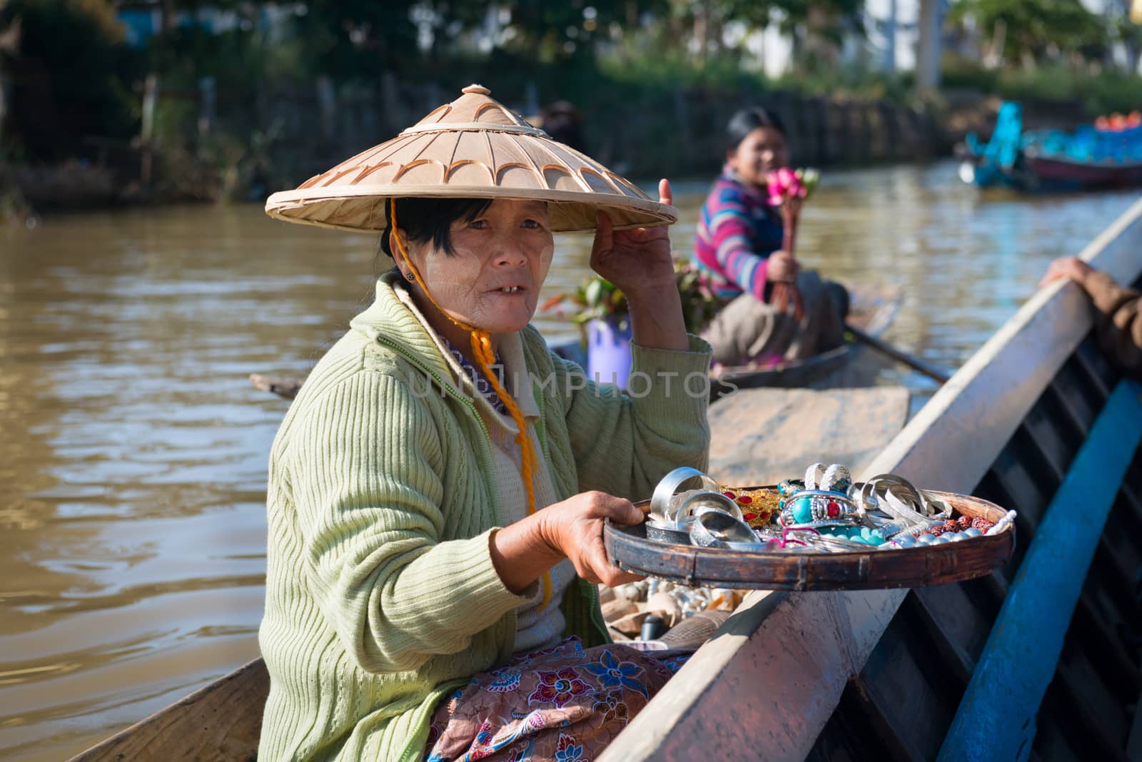 INLE LAKE, MYANMAR - 07 JAN 2014: Floating vendor on small  long wooden boat sell trinkets and bijouterie to tourists