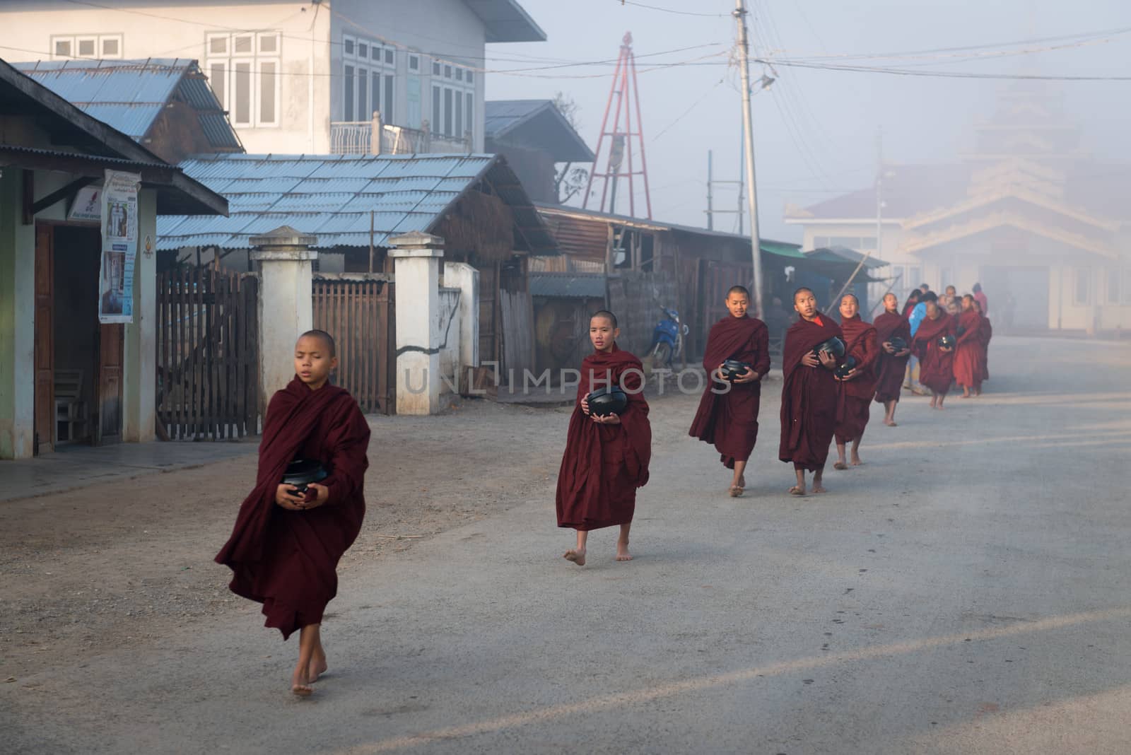 Young monks get food offerings in early morning by iryna_rasko