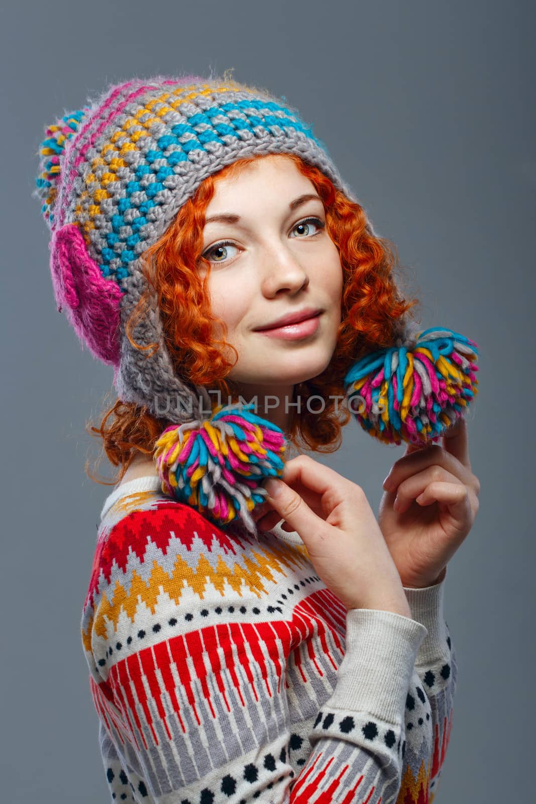 Attractive young red-haired girl in a warm knitted hat