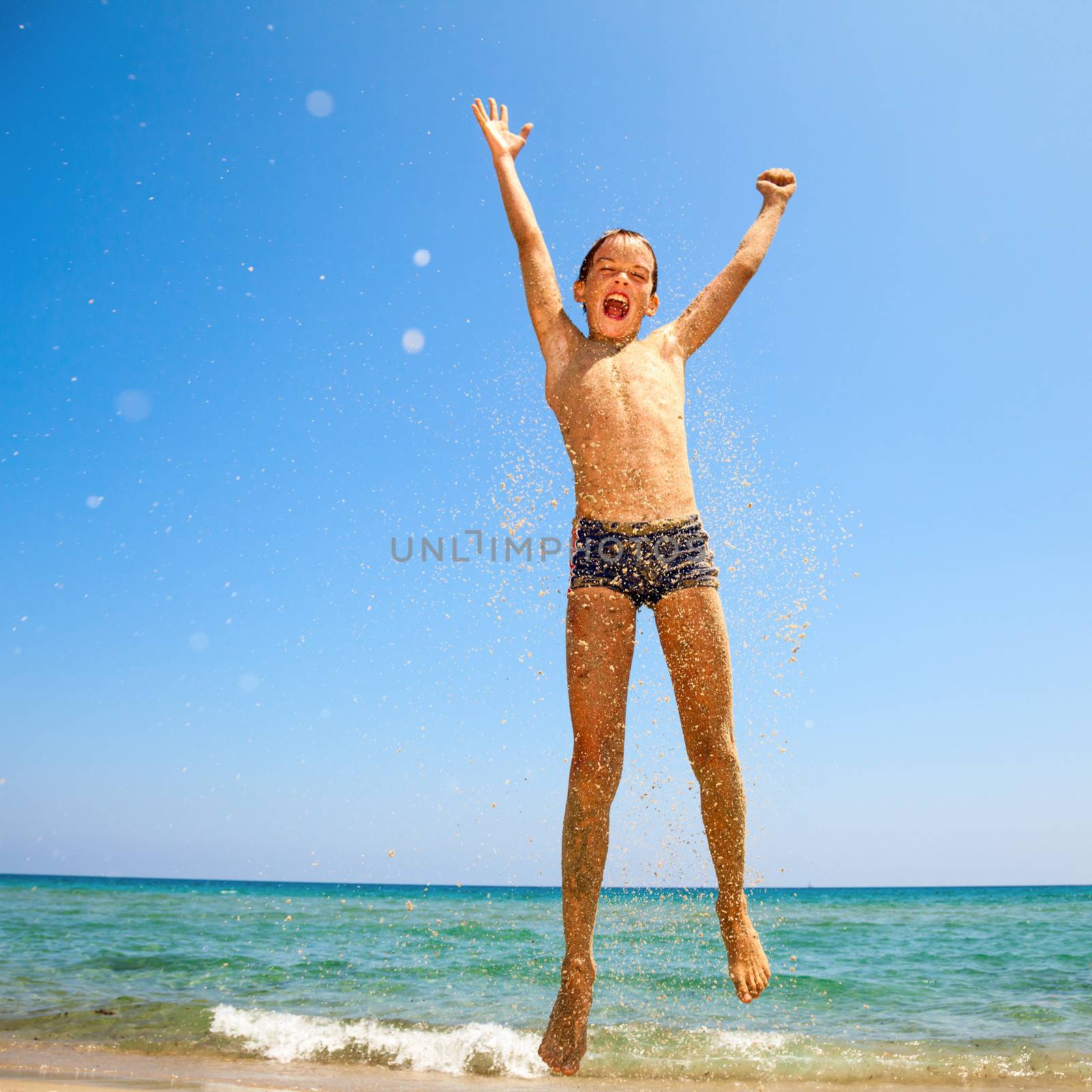 Boy jumping on the beach by naumoid
