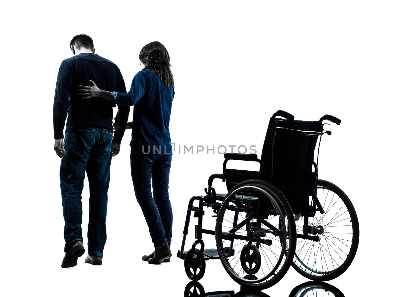 one man with woman walking away from wheelchair in silhouette studio on white background