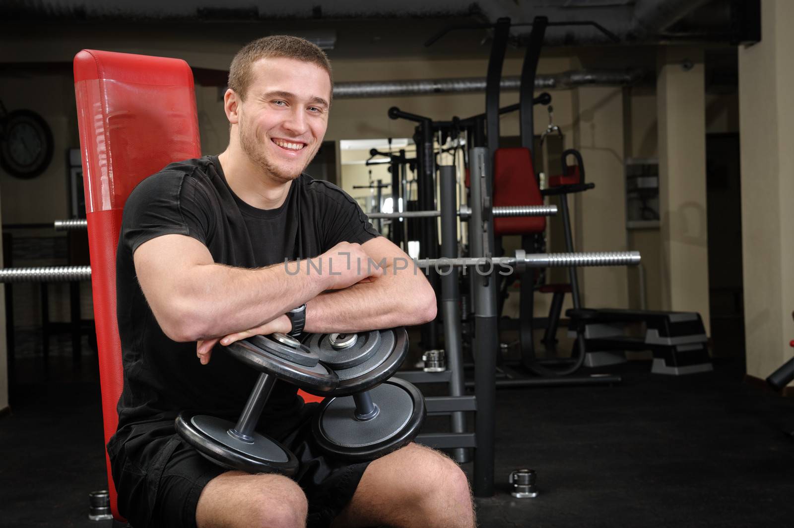 young handsome man sits after workout in the gym