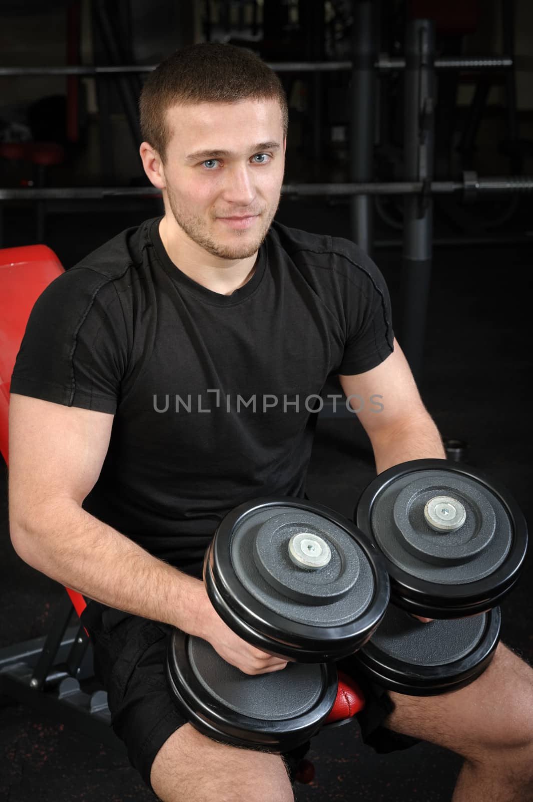 young handsome man sits after workout in the gym