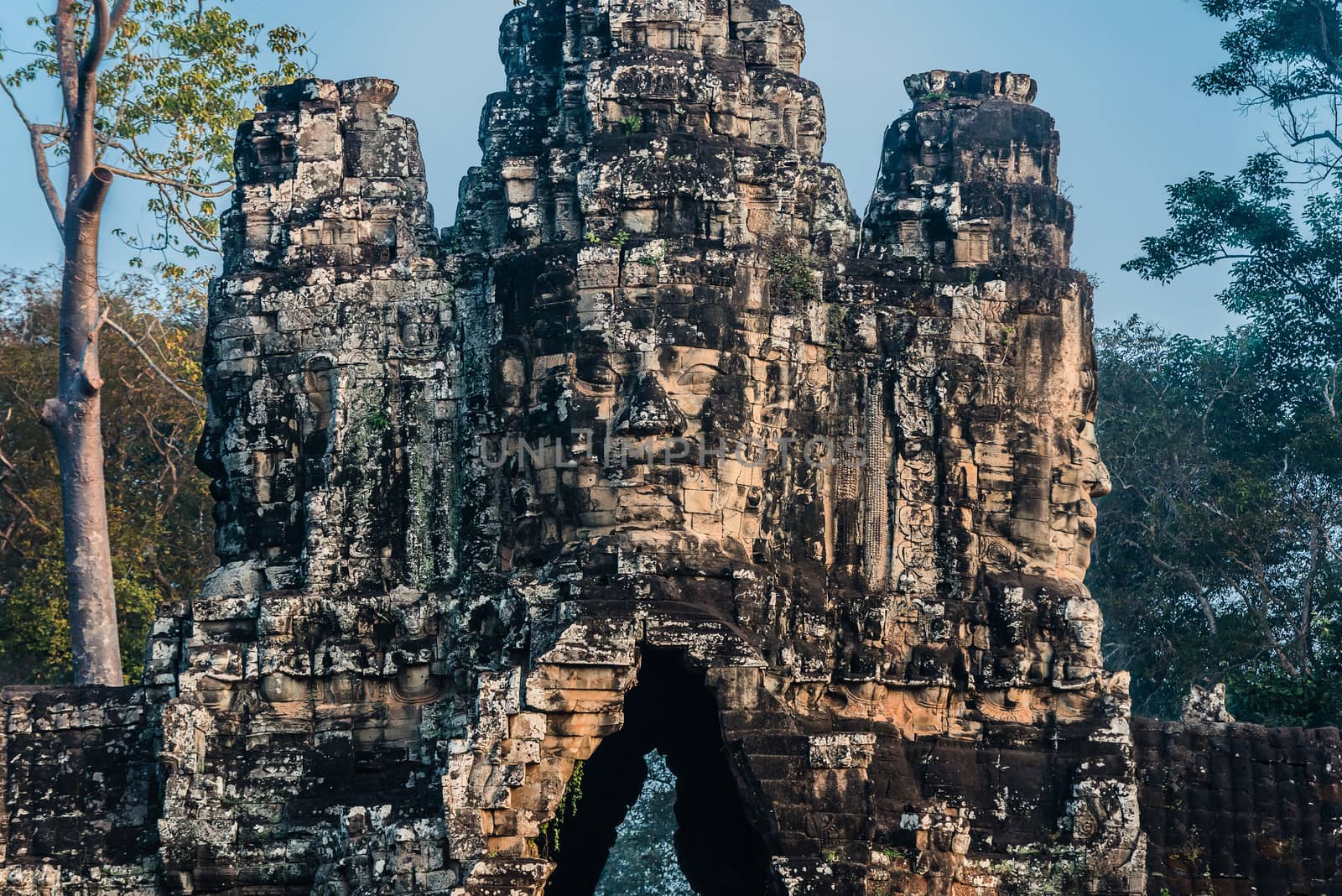 giant face south gate bridge angkor thom cambodia  by PIXSTILL