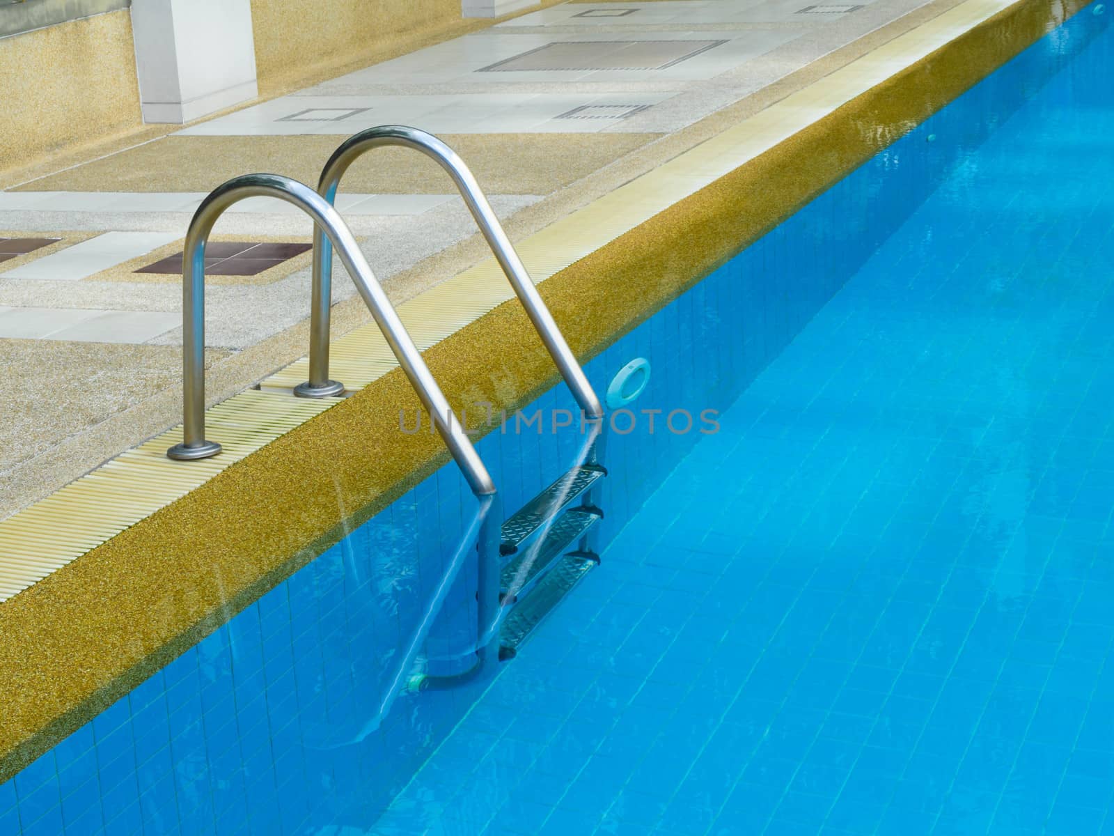 Grab bars ladder in swimming pool in daylight