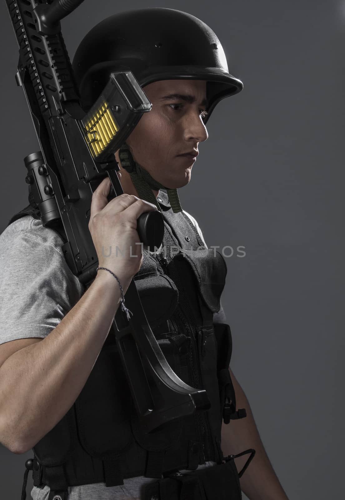 Safety, paintball sport player wearing protective helmet aiming pistol ,black armor and machine gun