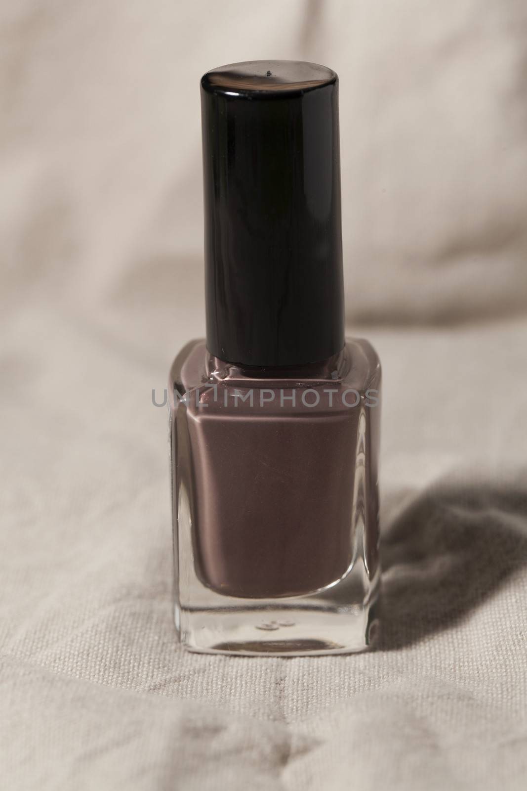 A nail polish bottle over beige background