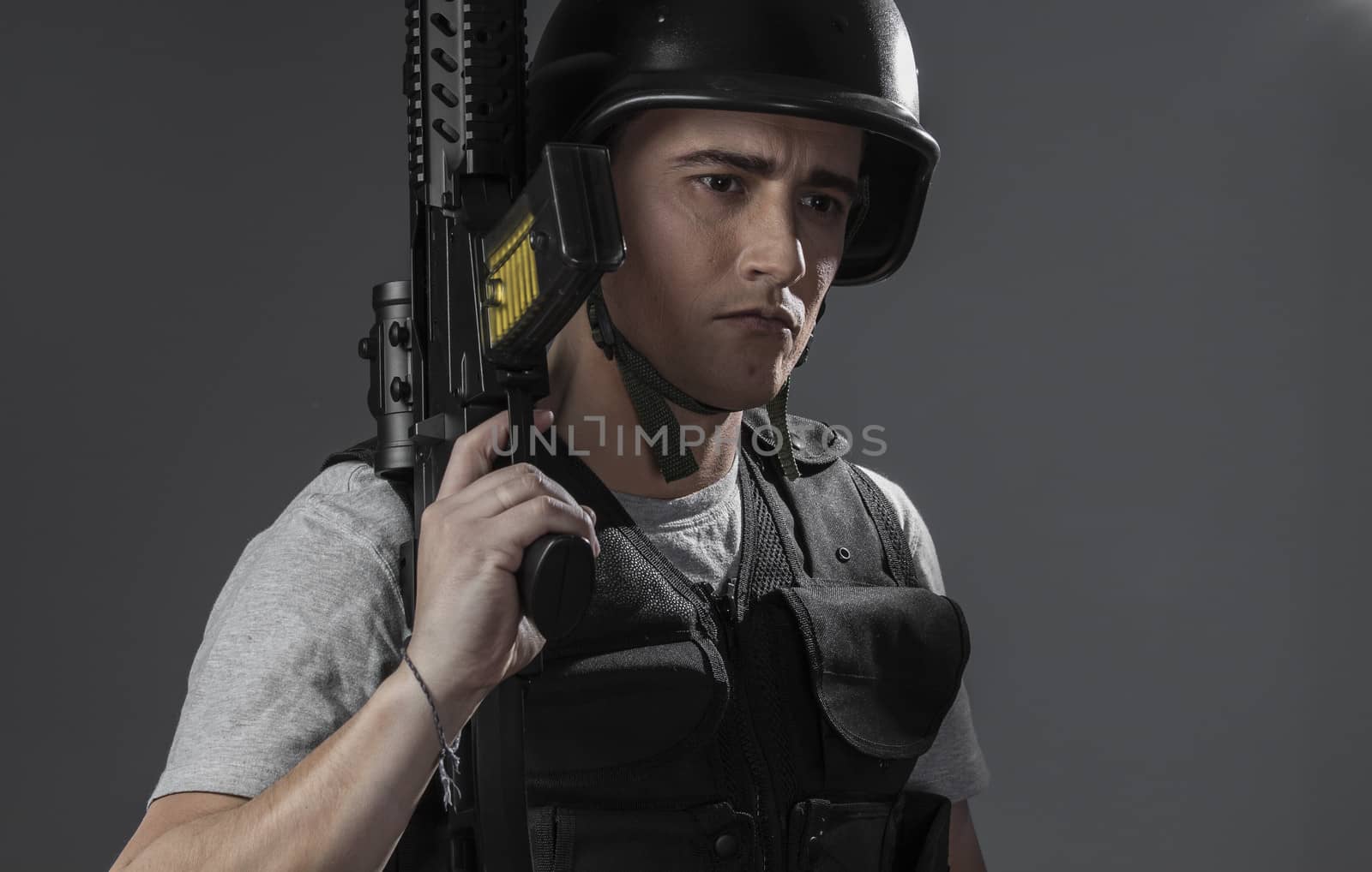 Assault, paintball sport player wearing protective helmet aiming pistol ,black armor and machine gun