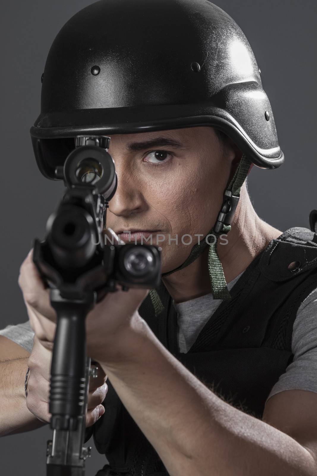 paintball sport player wearing protective helmet aiming pistol ,black armor and machine gun