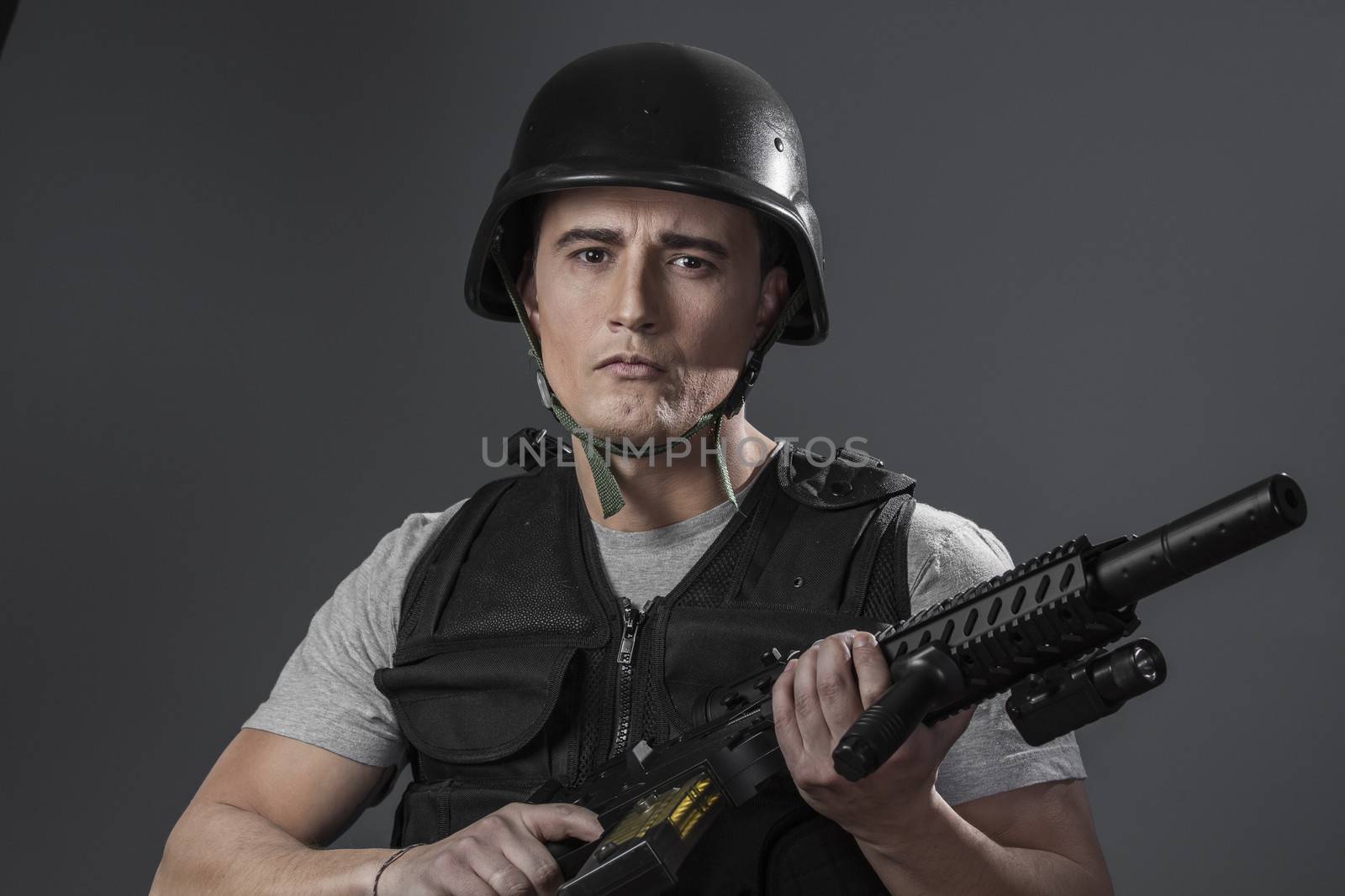 paintball sport player wearing protective helmet aiming pistol ,black armor and machine gun
