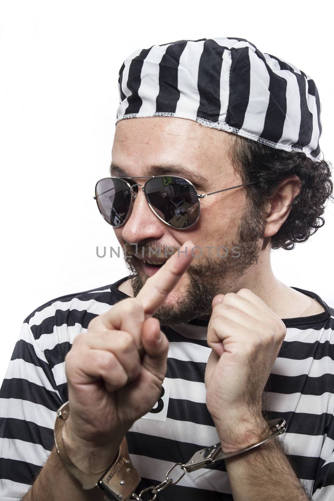 Funny man prisoner criminal with chain ball and handcuffs in studio isolated on white background