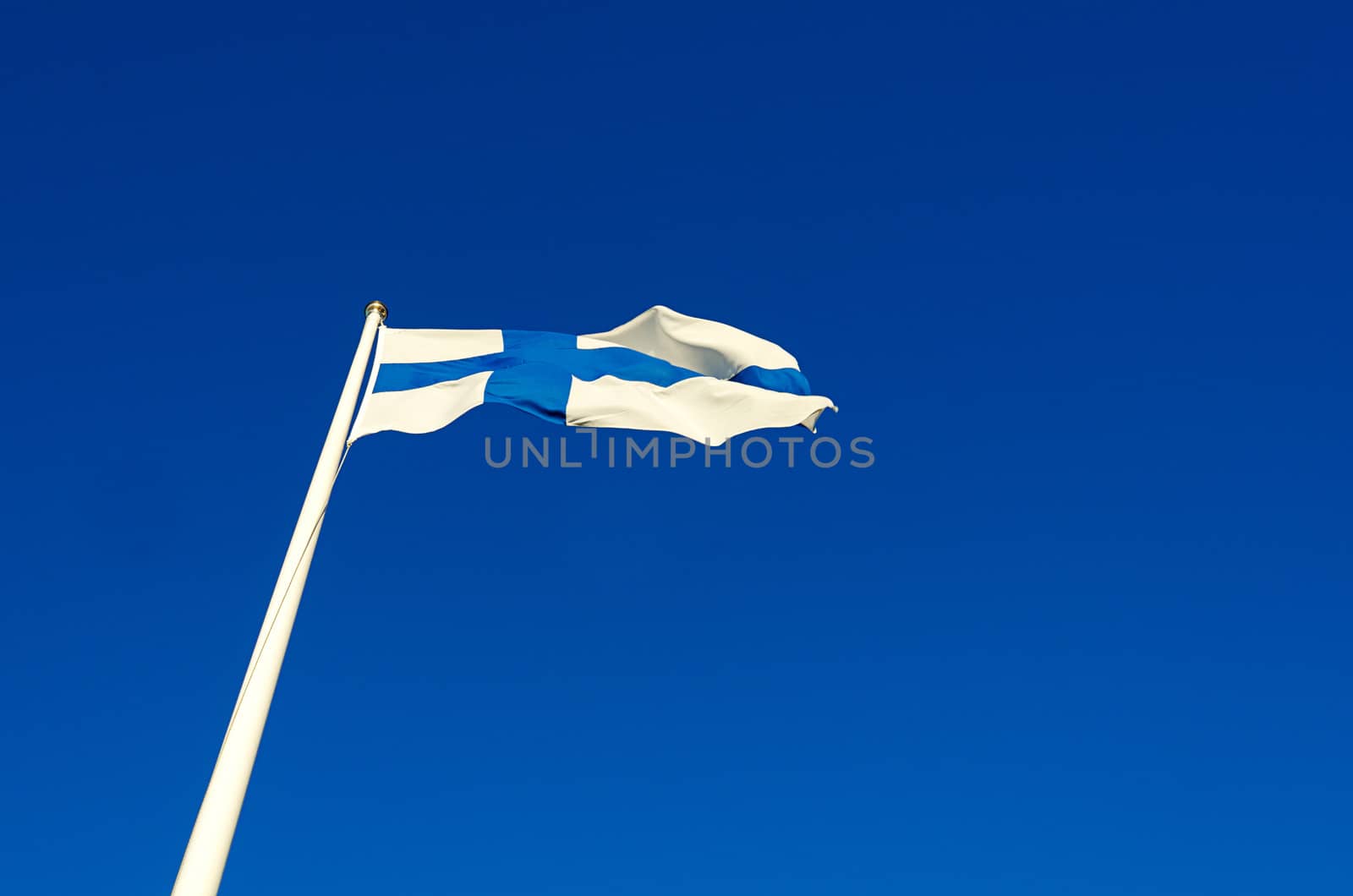 Finnish flag against a blue summer sky on a sunny day