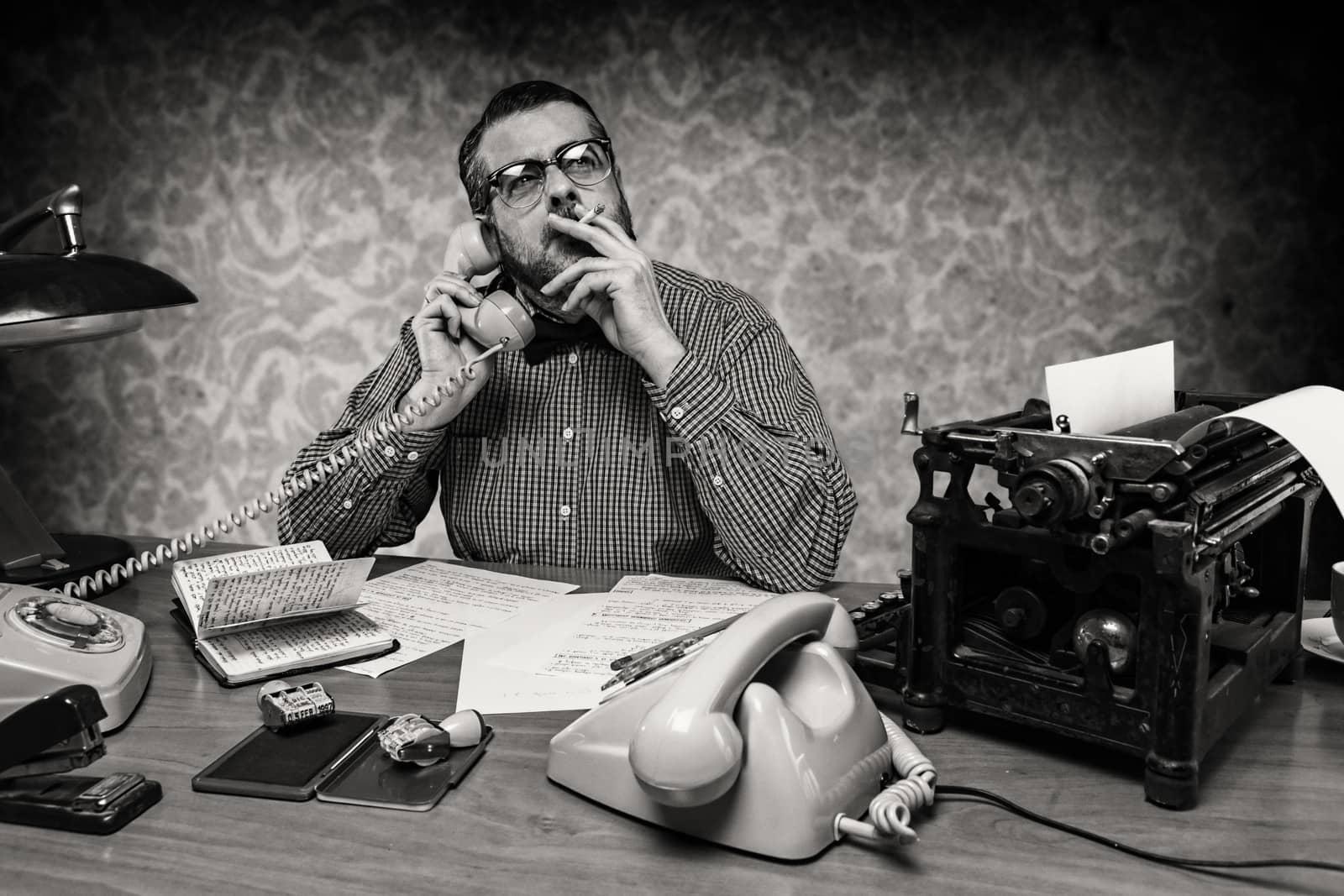 Man smoking a cigarette while talking on the phone, 1960's scene by digicomphoto