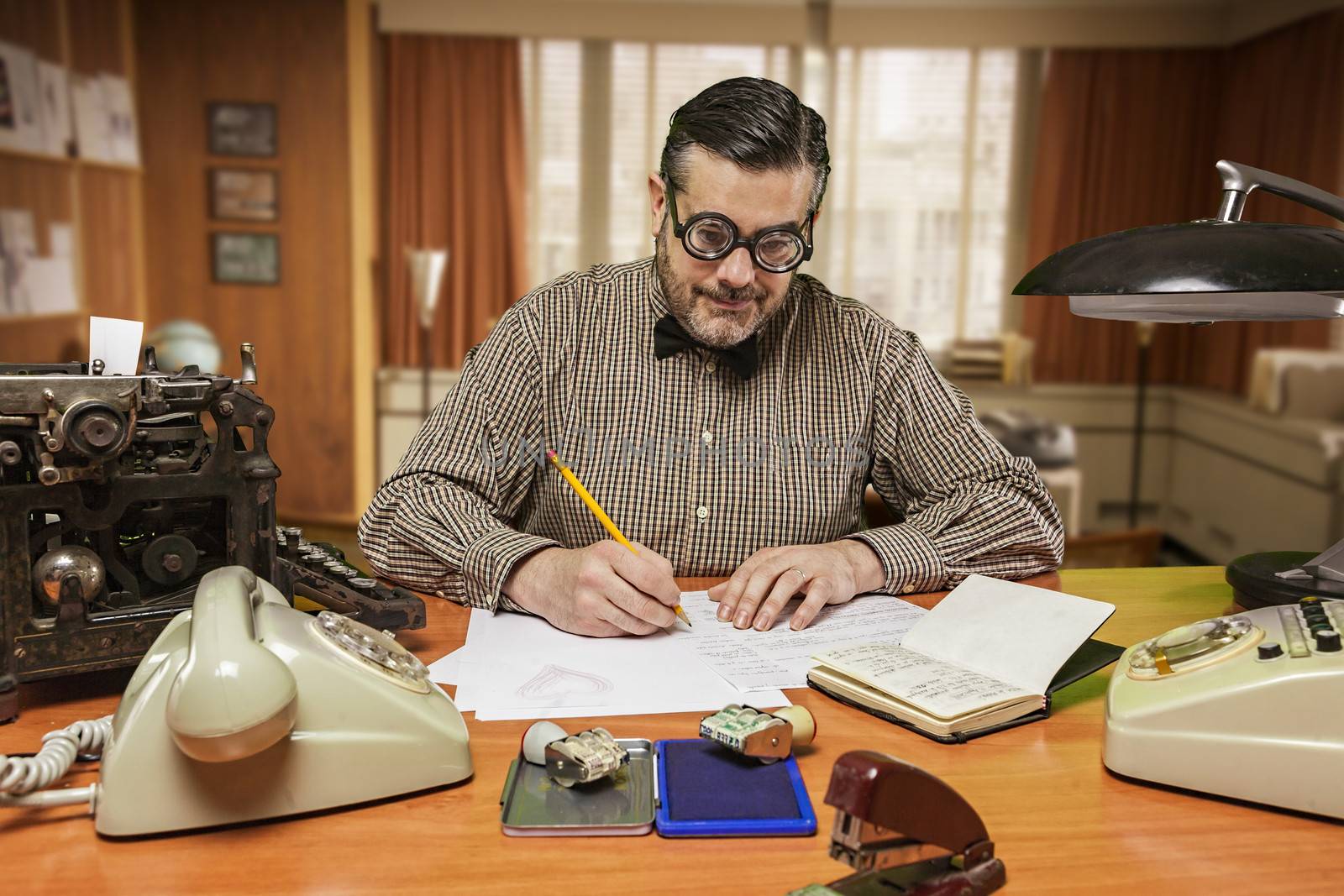 Employee with glasses working on your desktop in the 1960s by digicomphoto